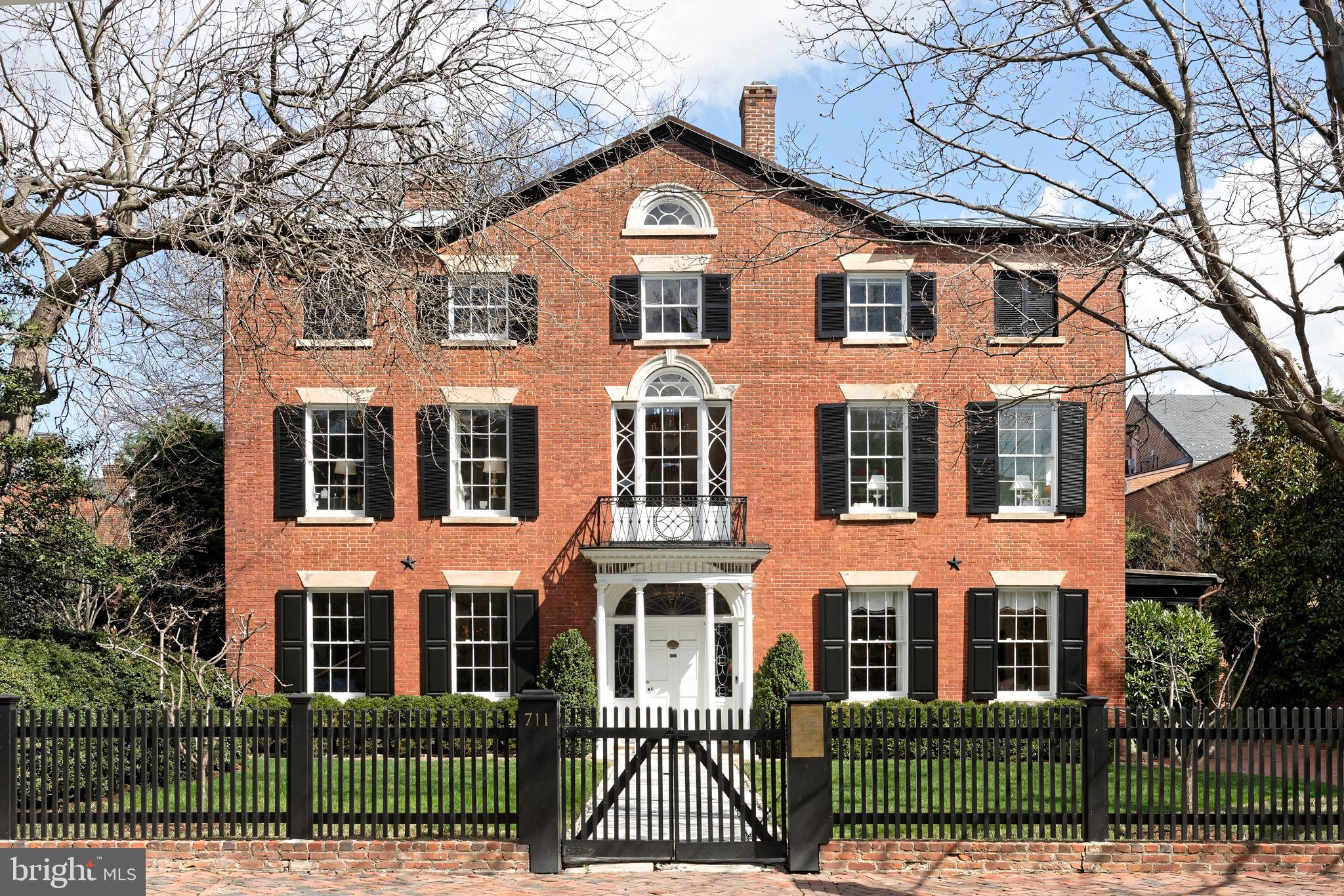 An Iconic Property Rich in History. Rarely does an offering like this come along, embodying a storied chapter in Old Town history. The Patton-Fowle House-attributed by some to renowned early American architect Charles Bulfinch of Boston-is one of America's finest examples of Federal high-style architecture, and among the largest, most distinctive gems in Alexandria, VA. This important landmark is protected by preservation easements in favor of the Commonwealth of Virginia and Historic Alexandria Foundation. Construction began in 1806 by James Patton and was completed in 1815 by wealthy shipping merchant and banker William Fowle of Boston. The home remained in the Fowle family until 1969, and has since been thoughtfully expanded, restored and modernized.  Magnificence in Every Detail. This exquisite freestanding residence set on spacious lushly landscaped grounds boasts 6 bedrooms and 5.1 baths, not to mention many wonderful period details and high-end upgrades. A covered porch and gorgeous entrance greet you upon arrival, graced by a leaded glass fan light & side lights restored by Mr. Goldkuhle, a famous leaded glass expert who helped restore windows at the National Cathedral. An original front door opens to a striking entry hall featuring a turned original staircase with shadow rail. Interiors impress with tall ceilings, original ornate plaster crown moldings, tasteful millwork, 8 lined fireplaces with original mantels & surrounds (several with coal baskets made in England which light with a gas flame), antique crystal chandeliers from England, and hardwood floors.   Exceptional Design and Comfort. While very grand, the home affords a comfortable, contemporary style of living desired by today’s discerning buyer. Perfectly proportioned rooms are designed for both intimate and large-scale entertaining. The large living room for cocktail parties and holiday gatherings, and elegant dining room for sit-down meals are very inviting, brightened by oversized windows. The new addition with a lovely family room is less formal and great for casual get-togethers and movie nights. A bar, fireplace, heated floors & sets of French doors enhance the ambience. The chef will be inspired in the gourmet kitchen equipped with honed marble countertops, a Lacanche French gas stove with double oven plus wall oven in the large center island, Sub-Zero refrigerator, 2 freezer & 2 warming drawers, and a wine fridge. An open breakfast/sitting room with fireplace has a window wall & glass doors to expansive terraces that stretch the entire back of the house. Outdoors is a dream for hosting and an oasis for relaxing with family, complemented by an enormous yard with mature trees & plantings. Electric driveway gates open to provide off-street parking for multiple cars. Rounding out the main level is a beautiful powder room.  Generous, Gracious Living. Ascend the staircase or take the elevator (which accesses three levels) up to a 2nd story landing showcasing a splendid Jeffersonian window and original ornate iron exterior railing. Your luxurious master retreat awaits, with remote-controlled draperies, original floors, a gas fireplace, phenomenal his & hers closets and new white marble en-suite spa bath with in-floor heating. Level 2 also has 2 additional bedrooms (one now used as an office) and a renovated bath. The top floor with a dramatic barrel-ceiling landing offers 3 more sizable guest rooms and 2 well-appointed full baths. The lower level haven presents a fabulous bricked wine room, exercise room with heated floor, laundry, full bath, and excellent storage areas.  Don’t miss this true treasure situated in the historical district, a short stroll to the waterfront and all the premium attractions for which coveted Old Town is known.