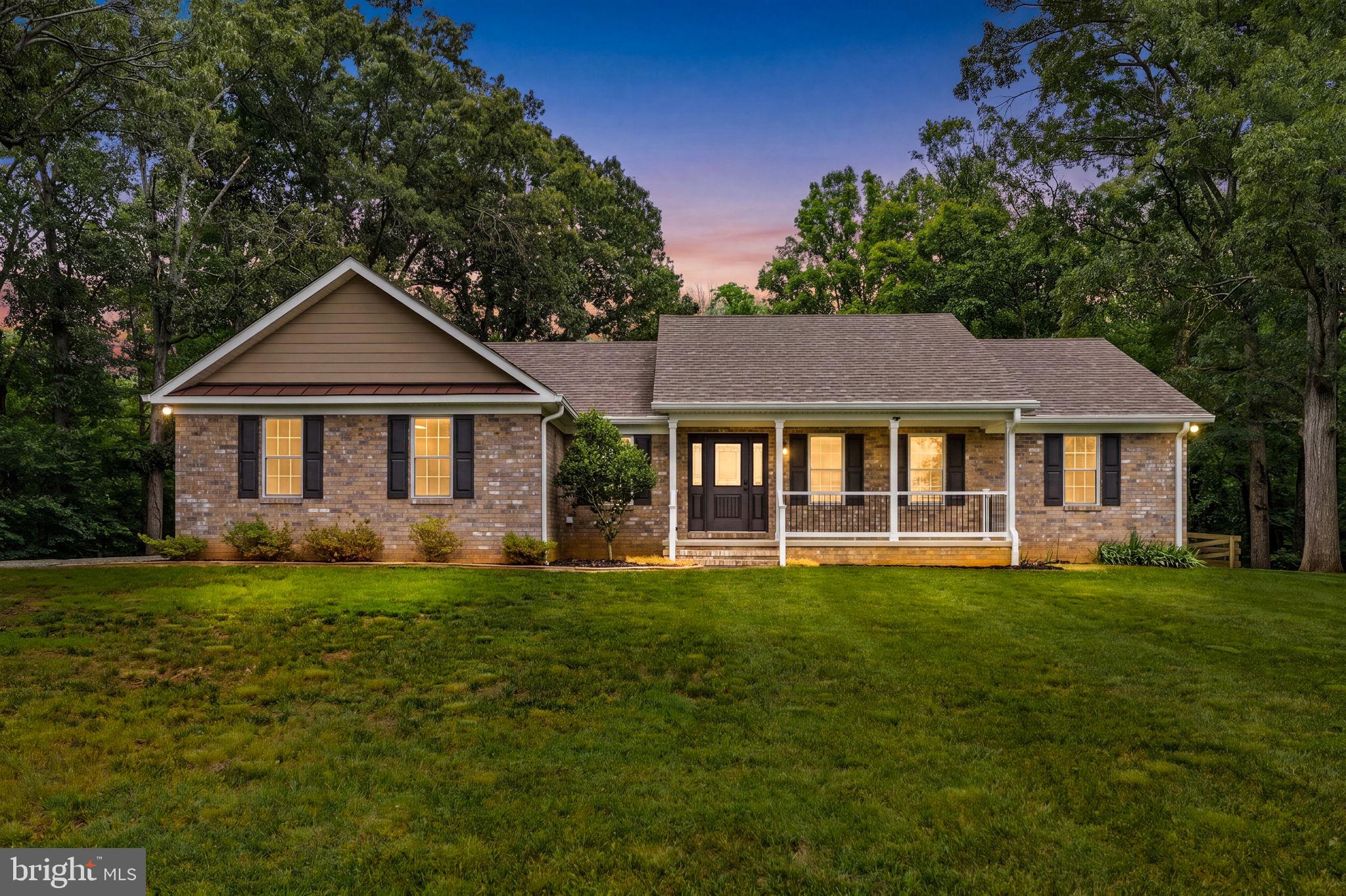 WELCOME HOME – Charming 3+Bedroom, 4-Bath Rambler on 9+ Private Acres
This  brick rambler is nestled on over 9 acres of serene, wooded Virginia countryside and only 5 years old! The property offers privacy, space, thoughtful upgrades throughout, and combines classic appeal with modern comforts with endless potential for outdoor living!
The inviting front elevation features warm brick, a welcoming covered porch, and mature trees framing the property. Step inside to discover a functional and comfortable open layout with vaulted ceiling, main-level living at its best. All three bedrooms include generous walk-in closets, and the primary suite boasts a luxurious soaker tub, heat lamp, and private walk-in closet that can be accessed from the bath or bedroom! The main-floor laundry room adds everyday convenience.

Notable Upgrades & Features:
• 50-year shingle roof for lasting protection
• Foam insulation throughout the entire home for superior energy efficiency
• Whole-house generator for peace of mind during power outages
• Inline water heater with circulator to the primary bath and whole-house water filter
• Insulated outer garage wall (upgrade!)
• Brick and Hardie board siding
• Screened porch perfect for relaxing evenings
• Built-in planters for easy gardening or landscaping touches
• Upstairs composite bamboo flooring
• Comcast high-speed internet available
The fully finished walk-out basement is a standout, featuring a full bath with shower and a dedicated dog-wash area — ideal for pets, hobbies, or additional living space that opens directly to the backyard.
Outside, enjoy the expansive, gently rolling lawn surrounded by towering trees. Additional highlights include:
• A 3-stall pole barn for equipment, or workshop space
• Plenty of room for gardening, recreation, or future expansion
Whether you’re looking for a peaceful country retreat, hobby farm, or family homestead, this property delivers it all. With its solid construction, practical upgrades, and abundant acreage, 9711 Clarke’s is ready for you to make it your own.
Schedule your private showing today and experience the tranquility this special home and land have to offer!