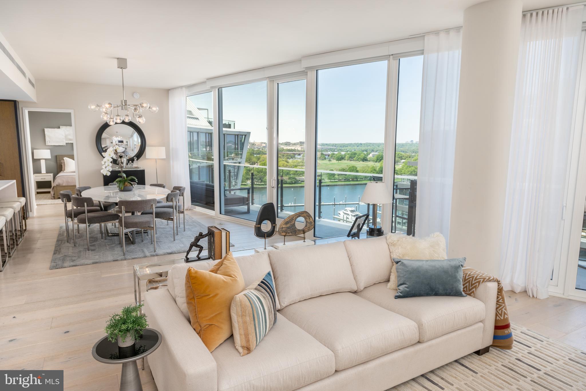 Welcome to the pinnacle of waterfront luxury at Amaris, an architectural statement by Rafael Viñoly and the crown jewel of The Wharf. This striking penthouse offers two bedrooms, a den, and two and a half baths — wrapped in elevated design and rarefied views. The open-concept living and dining areas are framed by floor-to-ceiling windows, automated shades, and wide-plank French oak hardwood floors, creating a seamless flow of light and air. A private terrace spans the full length of the residence, offering dramatic panoramas of the Potomac River, The Wharf, East Potomac Park, and beyond — a breathtaking backdrop for everyday living and elegant entertaining. The adjacent chef’s kitchen is equipped with Stevali Italian cabinetry, marble countertops, and top-of-the-line appliances, blending beauty and functionality for everything from weeknight dinners to curated events. The gracious primary suite features terrace access, ample custom closet space, and a spa-inspired bathroom designed for restoration. Both bedrooms enjoy floor-to-ceiling windows, flooding each space with light and river views. A versatile den completes the layout, ideal for a home office or media lounge. Additional highlights include two garage parking spaces with EV charging, an oversized private storage unit, and access to Amaris' world-class amenities: 24-hour concierge, valet service, indoor lap pool and jacuzzi, and a two-level fitness center outfitted with Peloton equipment. Outside your door, The Wharf delivers an unmatched lifestyle — with celebrated restaurants like Del Mar, Moon Rabbit, Officina, and more just steps away. This penthouse isn’t just a place to live — it’s a statement of arrival.
