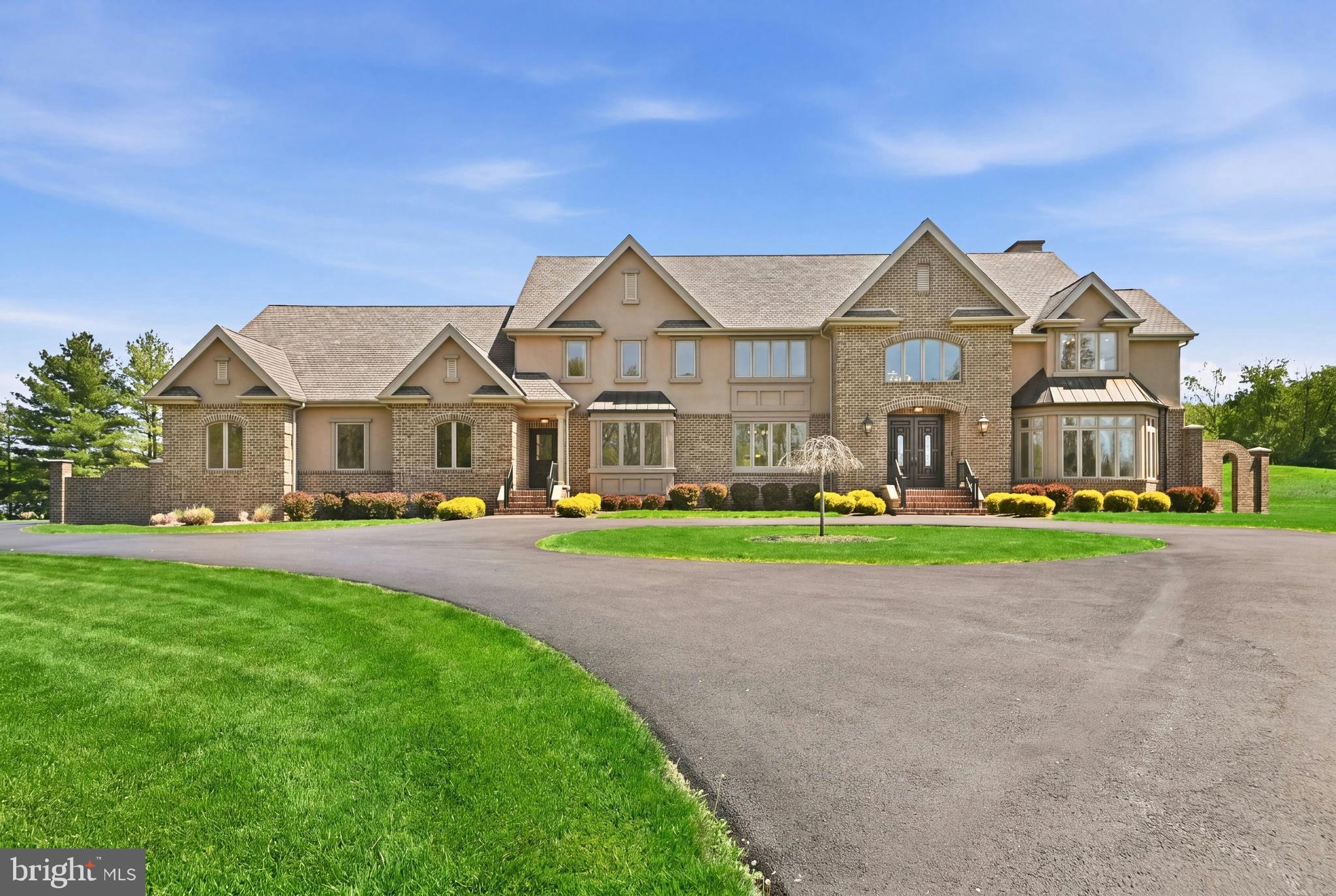Broadmoor, an exceptional Estate set on over 6 beautiful acres in iconic Bucks County. Broadmoor pairs privacy with prestige in the premier township of Solebury. A sweeping circular driveway creates a grand approach to the Main Entrance. A Secondary Entrance streamlines daily access to living spaces and a Private Office. Ideal for work-from-home, deliveries and catered events. Move-in ready, this home looks brand new. Expansive windows brighten each room with natural light, while flexible spaces adapt to your lifestyle. A Private Elevator connects all levels, bringing comfort and convenience to daily life and multi-generational living. The Private Office, with a double-door entry and scenic window seat, inspires focused work, creativity and quiet escape. Comfort meets energy-efficiency with 8-zones of eco-conscious Geothermal heating and cooling, a rare luxury. A standout feature, 2 Primary Suites with spa-inspired Baths featuring double vanities, integrated beauty zones, soaking tubs, showers, tray ceilings and heated floors. Suite One stuns with a double-door entry, double-sided fireplace with onyx hearth, sitting area, 2 walk-in closets, glass doors and tray ceilings. Suite Two impresses with elegant columns framing a sitting room and dual double-door entries, one to the bath and one to a spacious walk-in closet. Perfect for guests or multi-gen living. Two additional roomy Bedrooms, each with a walk-in closet, share a large full Bath with heated floors. A boutique hotel-style hallway reveals a rare gem, an expansive unfinished Private Wing near the Elevator and Secondary Staircase. Ideal for a gym, yoga retreat, art studio, 5th bedroom or in-law/au pair suite. On the 1st Floor, the Grand Foyer dazzles with a floating staircase, graceful arches and sweeping balconies. Walls of windows fill the Living Room with panoramic seasonal views, while stately columns define a Dining Room ready to impress. An adjacent Butler’s Pantry keeps events stress-free. Soothing, nature-inspired tones of the Gourmet Kitchen wrap you in the comforting warmth of home. From busy mornings to weekend gatherings, the expansive island, with prep sink and seating, invites connection and conversation. Abundant cabinetry, walk-in pantry and custom workstation simplify daily living. A sculptural Planter with polished river rock stones and columns adds artistic flair. Casual dining shines in the Breakfast Room with panoramic views by day and moonlit skies by night. For cozy evenings and relaxed gatherings, the Great Room sets the mood with a floor-to-ceiling fireplace, an oversized hearth built for seating, French doors, archways and warm cabinetry. Double sliding glass doors open to a Covered Terrace with skylights above. Unwind, savor meals and host with ease amid grand columns, custom balusters and a private backyard oasis. Quality conveniences include 2 Powder Rooms, a spacious Laundry, statement lighting, a chandelier lift, quartz countertops, soft-close wood cabinetry and a wealth of closets with customizable storage to keep life comfortably organized. The massive 3+ car Garage, perfect for car or garden enthusiasts, has soaring ceilings, natural light, a double sink, storage closet and a private entrance. The massive, dry Lower Level with 9-ft ceilings is a premium flex space for a home theater, wine room or multi-gen living. Low-maintenance by design, the level land blends green lawn, wildflower meadows and natural areas, with plenty of space for a pool and sports court. Located just minutes from walkable towns, dining, markets, galleries, entertainment and top schools. With quick access to Philadelphia, New York, Poconos skiing and Jersey beaches, weekday living and weekend escapes are refreshingly convenient. Schedule your private tour of Broadmoor, crafted to elevate everyday living in a meaningful way.