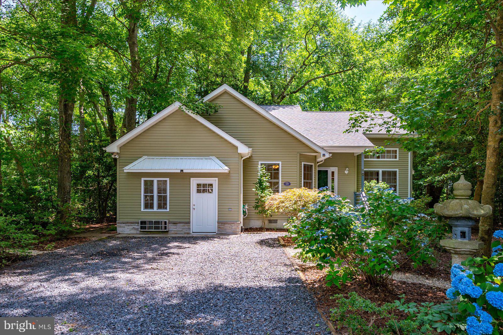 Enjoy the rest of your summer in this charming, contemporary three-bedroom-plus home, beautifully nestled among mature trees on an oversized lot at the end of a peaceful cul-de-sac.
With inviting living spaces, step through the front door into a spacious open living area with soaring ceilings, bathed in natural sunlight. The space features hardwood flooring and a cozy wood-burning fireplace, creating a warm and welcoming atmosphere. And there is an adjacent office or den.  
Flexible Bonus Room and Updated Features:
A special feature of the home is the converted garage, which now serves as a versatile room—perfect for a home business, office, exercise room, or hobbies. This space includes a separate entrance and a half bath for added convenience. Adjacent to the laundry room, you will find a large walk-in pantry with abundant shelving, an additional refrigerator, and a chest freezer.
The primary bedroom and bath are conveniently located on the first level, while the second level offers two additional bedrooms, a full bath, and a generous walk-in attic, providing ample space and flexibility for your needs. 
Recent updates include a brand-new roof with architectural shingles, and the warranty will transfer to the new owners. The HVAC system was updated in 2022. The interior was freshly painted throughout, all carpeting has been replaced with a neutral shade, and the wood flooring has been sanded to look like new.
Outdoor Living and Curb Appeal:
Relax or enjoy steamed crabs on summer evenings in your three-season porch with a tiled floor, overlooking the private backyard. The front yard is nicely landscaped and features an antique Japanese lantern, adding a touch of elegance. A large driveway provides ample parking for guests.
This is a must-see home!
Experience life in Ocean Pines, an award-winning community filled with amenities such as indoor and outdoor swimming pools, a championship golf course designed by Robert Trent Jones, tennis and pickle ball courts, a Yacht Club and Marina, Beach Club, Community Center, Saturday Farmers Market, library, Post Office, shops, restaurants, and more—delivering prime coastal living.