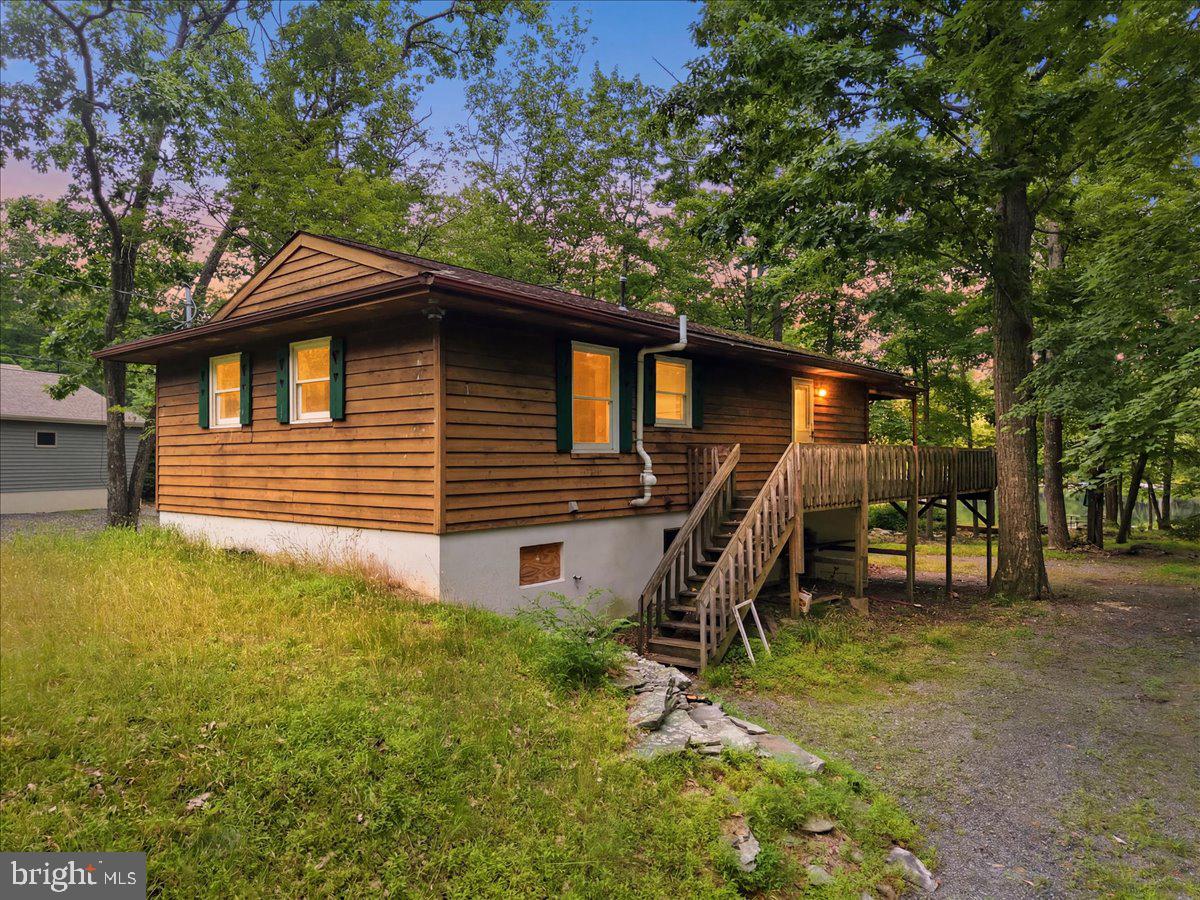 86 FEET OF GORGEOUS LAKEFRONT! -- the one thing no renovation can add! This raised ranch needs extensive work, and the price reflects it honestly. What it doesn't need is a better setting. Three bedrooms, three full baths, a bonus room, and a walk-out lower level with family room and wood stove for cool mountain evenings. Bring your vision and build real equity on frontage that simply can't be replicated. Amenity-rich community includes clubhouse, fitness center, pool, tennis courts, playground, picnic area, security, and snow removal. Minutes to Shawnee Mountain skiing, premier golf at Great Bear Golf Club, shopping, and Bushkill Falls. Being sold as-is.