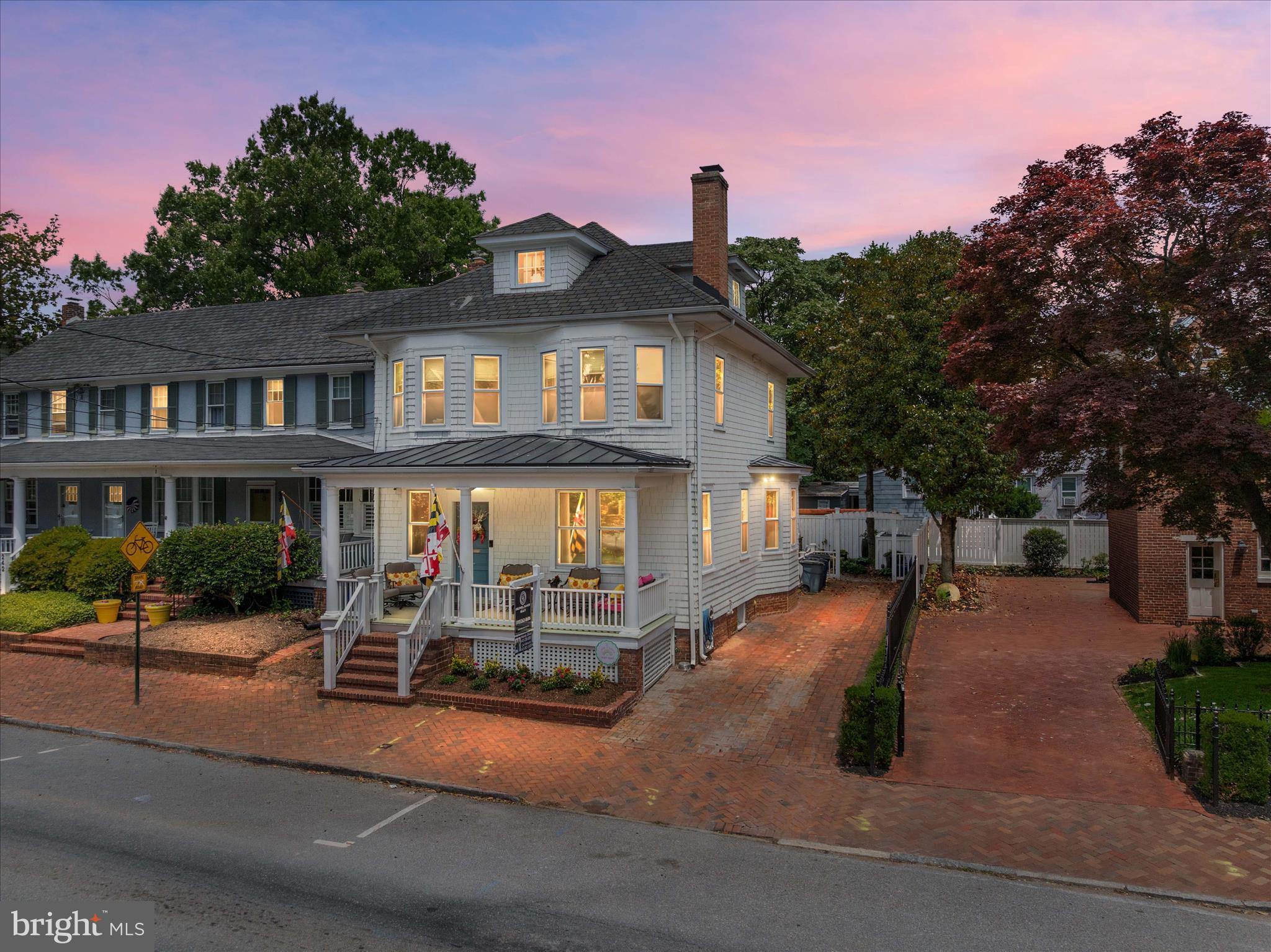 Perfectly positioned on prestigious King George Street in the heart of Historic Annapolis, this exceptional residence offers a rare combination of timeless character, luxury updates, coveted off-street parking, breathtaking views of the United States Naval Academy Chapel dome, and the convenience of turnkey living. Located just steps from State Circle, the Naval Academy, City Dock, waterfront dining, boutique shopping, and the charm of downtown Annapolis, this is the lifestyle buyers dream about but rarely find.  Originally reimagined through a comprehensive renovation and continually improved through 2025, this home delivers all the architectural charm of a historic Annapolis residence while offering the modern conveniences expected today. Every detail has been thoughtfully considered, from the custom inlaid hardwood flooring and gracious entry foyer to the extensive millwork, coffered ceilings, recessed lighting, designer finishes, and beautifully updated living spaces throughout all four finished levels. Recent improvements completed between 2024 and 2026 include a brand-new roof, HVAC systems, water heater, freshly painted interiors, updated doors and hardware, lighting, fixtures, and numerous additional enhancements that make this home truly move-in ready.  The chef-inspired kitchen serves as the heart of the home and features custom cabinetry, built-ins, granite countertops, oversized center island, wine refrigerator, walk-in pantry, six-burner gas cooktop, premium appliances, and abundant storage. French doors open to a private courtyard garden inspired by classic English design, complete with a tumbled stone patio, pergola, landscape lighting, and fully fenced grounds that create an intimate outdoor retreat for dining, entertaining, or relaxing under the stars.  The second level hosts a luxurious primary suite with sitting area, walk-in closet, and spa-inspired bath featuring custom cabinetry, soaking tub, separate shower, and designer finishes. Additional bedrooms, ensuite accommodations, linen storage, and convenient second-floor laundry provide comfortable everyday living. The third-floor loft offers exceptional flexibility as a bedroom, office, studio, or guest retreat and opens to a rooftop terrace with picturesque views of the iconic Naval Academy Chapel dome.  The fully finished lower level adds remarkable living space rarely found in Historic Annapolis homes, offering high ceilings, separate walkout access, custom built-ins, wet bar, half bath, cedar storage closet, and expansive recreation areas ideal for entertaining, billiards, media, fitness, or guest accommodations.  One of the property's most valuable features is the private brick driveway providing off-street parking for three vehicles—an extraordinary amenity in downtown Annapolis.  Offered substantially furnished, this extraordinary residence presents a rare turnkey opportunity in Historic Annapolis. With only a few personal artwork pieces and select kitchen items excluded, the next owner can move in, begin enjoying the home immediately, or seamlessly continue its successful use as an income-producing luxury rental.  INVESTOR ALERT: The property has been successfully operated as a high-performing Airbnb generating substantial income for the current owner. Whether seeking a primary residence, second home, luxury retreat, or investment property, 238 King George Street offers a truly unique opportunity to own a beautifully updated piece of Annapolis history in one of the city's most coveted locations.  Live where others vacation. Walk to everything. Enjoy unmatched views, historic surroundings, modern luxury, and the very best of Annapolis living.