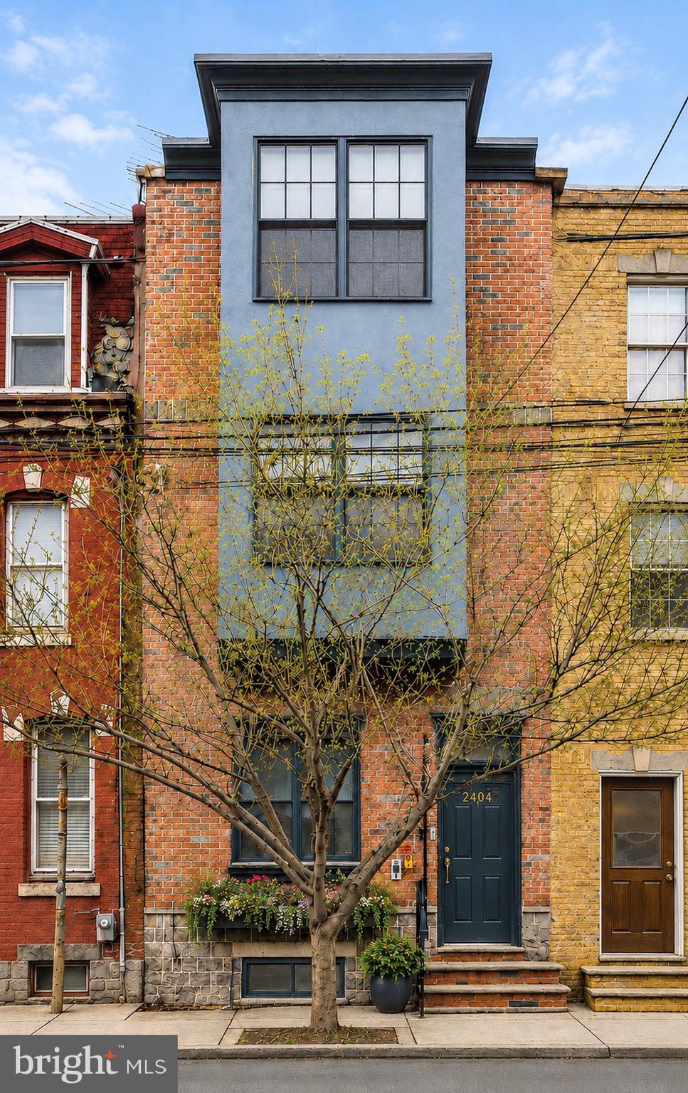 Welcome to 2404 Catharine Street, a fully customized and impeccably renovated townhome offering 4 oversized bedrooms, 2 full baths, and one half bath, and extraordinary outdoor living in the heart of Graduate Hospital, one of Philadelphia's most sought-after and walkable neighborhoods. Situated on a charming tree-lined street, this exceptional residence seamlessly blends timeless character with modern sophistication. Just moments from Fitler Square, Rittenhouse Square, the Schuylkill River Trail, UPenn, CHOP, Penn Medicine, Drexel University, and 30th Street Station, the home places the very best of city living right outside your door. Thoughtfully redesigned with meticulous attention to detail, the home welcomes you with a bright and expansive open floor plan featuring soaring ceilings, wide-plank hardwood flooring, recessed lighting, and beautifully defined living and dining spaces designed for both everyday comfort and effortless entertaining. At the center of the home is a stunning chef's kitchen featuring shaker-style cabinetry, quartz countertops, a farmhouse sink, under-cabinet lighting, stainless steel appliances, and a vented gas double-oven range with four burners and a griddle. A thoughtful combination of solid and glass-front cabinetry provides abundant storage, while a stylish powder room adds convenience. Sliding doors open directly to a spacious fenced patio, creating a seamless indoor-outdoor living experience that is perfect for morning coffee, al fresco dining, or gathering with friends and family. The home's desirable southern exposure fills the interior with natural light throughout the day. A thoughtfully designed awning offers privacy and shade during the warmer months, creating an inviting outdoor retreat for relaxing, dining, or entertaining. The second floor offers two generously sized bedrooms with ample closet space, and hardwood flooring throughout. The oversized hall bath is a rare luxury, featuring a double vanity, frameless glass shower, deep soaking tub, and a second shower, an exceptional level of comfort seldom found in city homes. The third floor is dedicated to the private primary suite and an additional bedroom, currently used as a home office, which is equally suited as a nursery, guest room, or flex space. The primary suite features two closets, recessed lighting, a ceiling fan, and a beautifully appointed bath with a spacious, frameless glass walk-in shower. A spiral staircase leads to the pilot house and expansive roof deck where breathtaking skyline views stretch in every direction. Whether enjoying morning coffee, entertaining guests, or watching the sunset over Philadelphia, this remarkable outdoor space delivers an unforgettable experience. Rebuilt with a new roof and maintenance-free engineered decking, it was designed for enjoyment with minimal upkeep. The finished lower level provides valuable additional living space ideal for a family room, den, playroom, media room, fitness area, or office. A full-size laundry area and substantial storage space add everyday practicality to the home's impressive list of amenities. Beyond the home itself, the location is truly exceptional. Enjoy easy access to some of Philadelphia's most celebrated restaurants, cafés, and neighborhood favs, including  Illata, Rival Bros Coffee, Pub & Kitchen, Southgate, Sabrina's, Thai Square, Sidecar Bar, Ultimo Coffee, Breezy's Deli, and Los Camaradas. Walking distance to your groceries at Heirloom Market, South Square Market, Aldi, and CVS are all just steps away. Outdoor enthusiasts will appreciate being close to Schuylkill River Park, the award-winning River Trail and Boardwalk, Markward Playground, tennis courts, dog park, and historic Rittenhouse Square. Commuters benefit from convenient access to I-76, I-95, Route 476, and Philadelphia's leading medical and educational institutions. Located within the highly sought-after Marian Anderson Neighborhood Academy Catchment. This is city living at its finest!