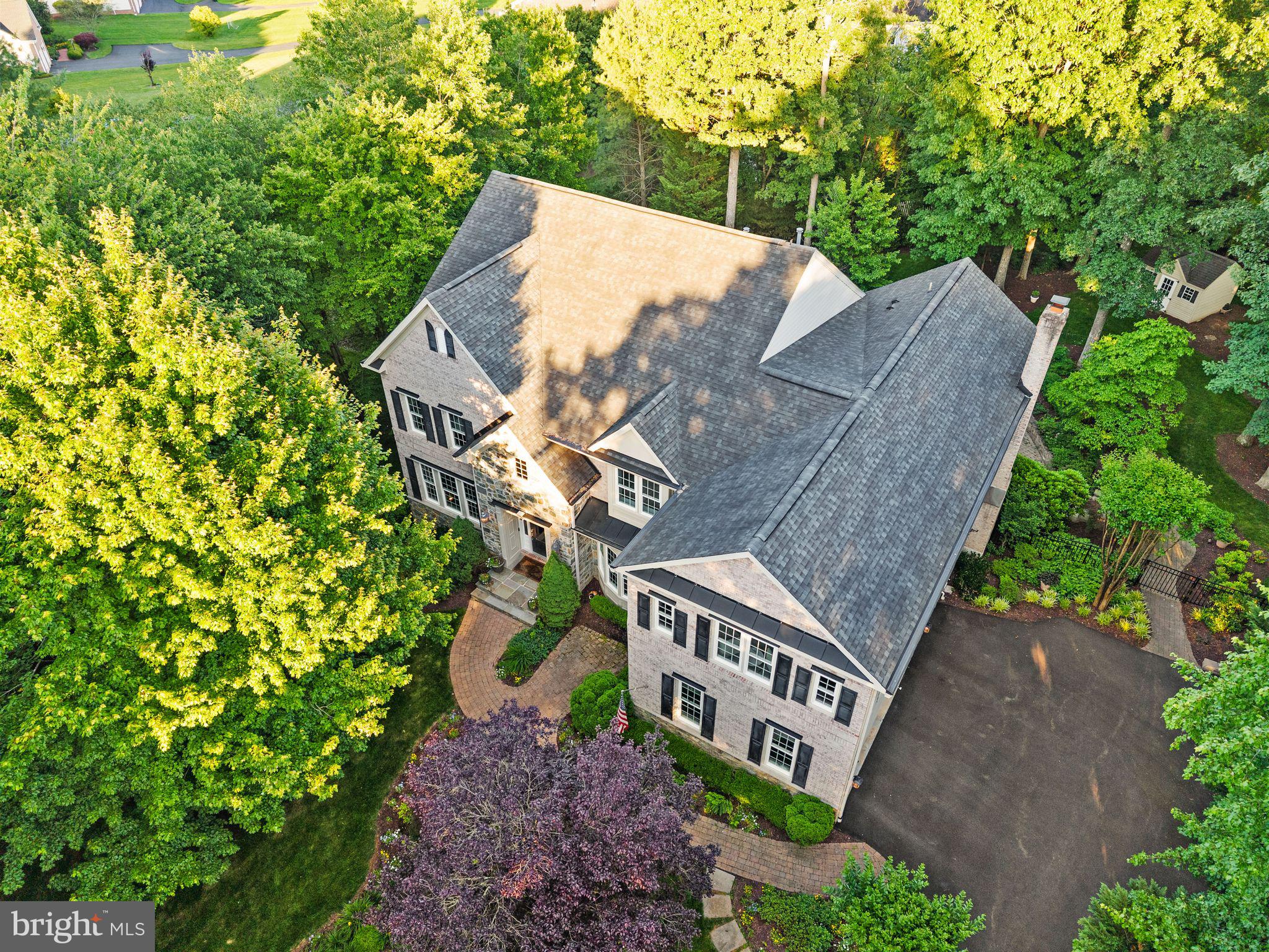 This stunning Craftmark-built estate home is perfectly sited on a private, premium .84-acre lot surrounded by mature hardwoods and storybook landscaping. Turn down the expanded driveway and watch as the foliage opens up to reveal this handsome home and breathtaking property. Offering an exceptional blend of elegance, privacy, and modern luxury, this distinguished residence is designed for both grand entertaining and comfortable everyday living. A dramatic two-story foyer welcomes guests with an elegant curved staircase, setting the tone for the refined interiors beyond. Rich wide plank hardwood flooring spans the main and upper levels, complemented by extensive decorative moldings. Custom premium lighting fixtures tie it all together. The main level unfolds with a stately drawing room highlighted by an oversized bay window and custom built-in bookcases. Formal living and dining rooms provide sophisticated spaces for entertaining, while the inviting step-down family room showcases a striking stone gas fireplace, walls of windows, and a convenient rear staircase to the upper level. At the heart of the home, the remodeled gourmet kitchen (2022) features quartz countertops, an expansive center island with sink, Bosch double ovens, two Bosch dishwashers, a five-burner Thermador cooktop with custom vent hood, built-in microwave drawer, quartz backsplash, wine storage, and a walk-in pantry.  Wow.  The adjoining solarium is bathed in natural light and features a vaulted ceiling, built-in cabinetry/bar, and a new atrium door opening to a private Trex deck overlooking the serene, rolling, wooded backyard. Upstairs, the luxurious primary suite serves as a private sanctuary, featuring a spacious sitting room, soaring vaulted ceilings, and dual walk-in closets outfitted with custom closet systems. The beautifully remodeled spa-inspired primary bath (2022) showcases a freestanding soaking tub, oversized glass-enclosed shower, designer LED vanity mirrors, and refined finishes throughout. 4 additional generously sized bedrooms complete the upper level, each with direct access to an ensuite bath, providing exceptional comfort, privacy, and convenience for family members and guests alike. The versatile walkout lower level is designed for entertaining and extended stays, offering a theater area, spacious rec room, an expansive workout room or a private guest room with ensuite bath . A whole-home audio system with integrated speakers throughout the residence, and a dedicated home theater system that conveys, elevates the entertainment experience. A separate workshop and another dedicated storage room provide exceptional flexibility and organization. Outside, the tranquil setting creates a true private retreat. This spectacular .84-acre wooded homesite allows the residents to enjoy a picturesque, park-like setting complete with a meandering creek that enhances the natural beauty and sense of serenity. The fenced backyard offers both privacy and functionality, complete with a storage shed for outdoor equipment and gardening essentials. Designed for exceptional outdoor living, the property features a built-in BBQ and expansive patio where you can grill, dine al fresco beneath sparkling café lights, and enjoy the peaceful surrounding grounds. A three-car side-load garage and extended driveway provide abundant parking for family and guests alike. Additional capital-intensive recent improvements include two new HVAC systems (2022), automatic blinds in the sunroom, family room, primary bedroom and bath, a repaved and widened driveway, water softening system (2023), and new patio doors in both the solarium and dining room, all of which ensure turnkey luxury and peace of mind for years to come. This nearly 8,000 sq ft showplace is truly one of a kind.  Enjoy Piedmont's resort-style amenities, including championship golf, tennis courts, fitness facilities, walking trails, and a vibrant community atmosphere. Check out the 3D Tours!