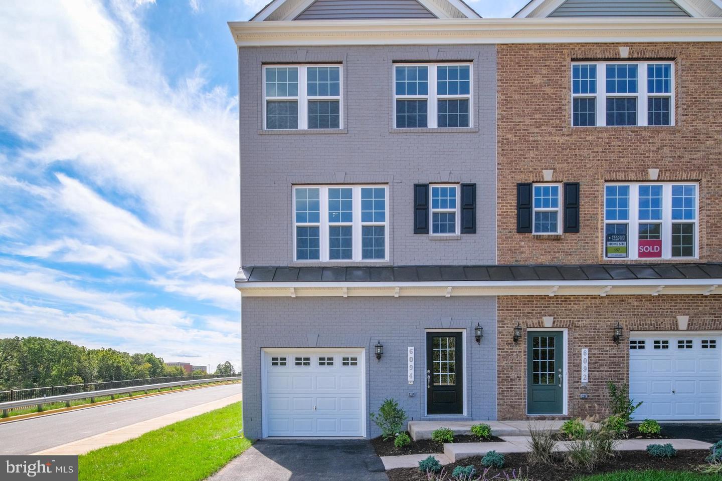 Welcome to this modern, fresh, end-unit townhouse that features four thoughtfully sized bedrooms, including a primary suite on the upper level with a luxurious frameless shower and a walk-in closet for added comfort and privacy. Hardwood flooring flows throughout the main level of the home. The gourmet kitchen boasts quartz countertops, stainless steel appliances, a cooktop, double wall ovens, and a 10' island, opening to a spacious living and dining area. Downstairs, a ground-level room offers a second private suite with its own full bath or a large family room space. This home also includes a one-car garage and a second driveway parking space. Step outside onto the large deck and relax in comfort. This home is ready for immediate occupancy.