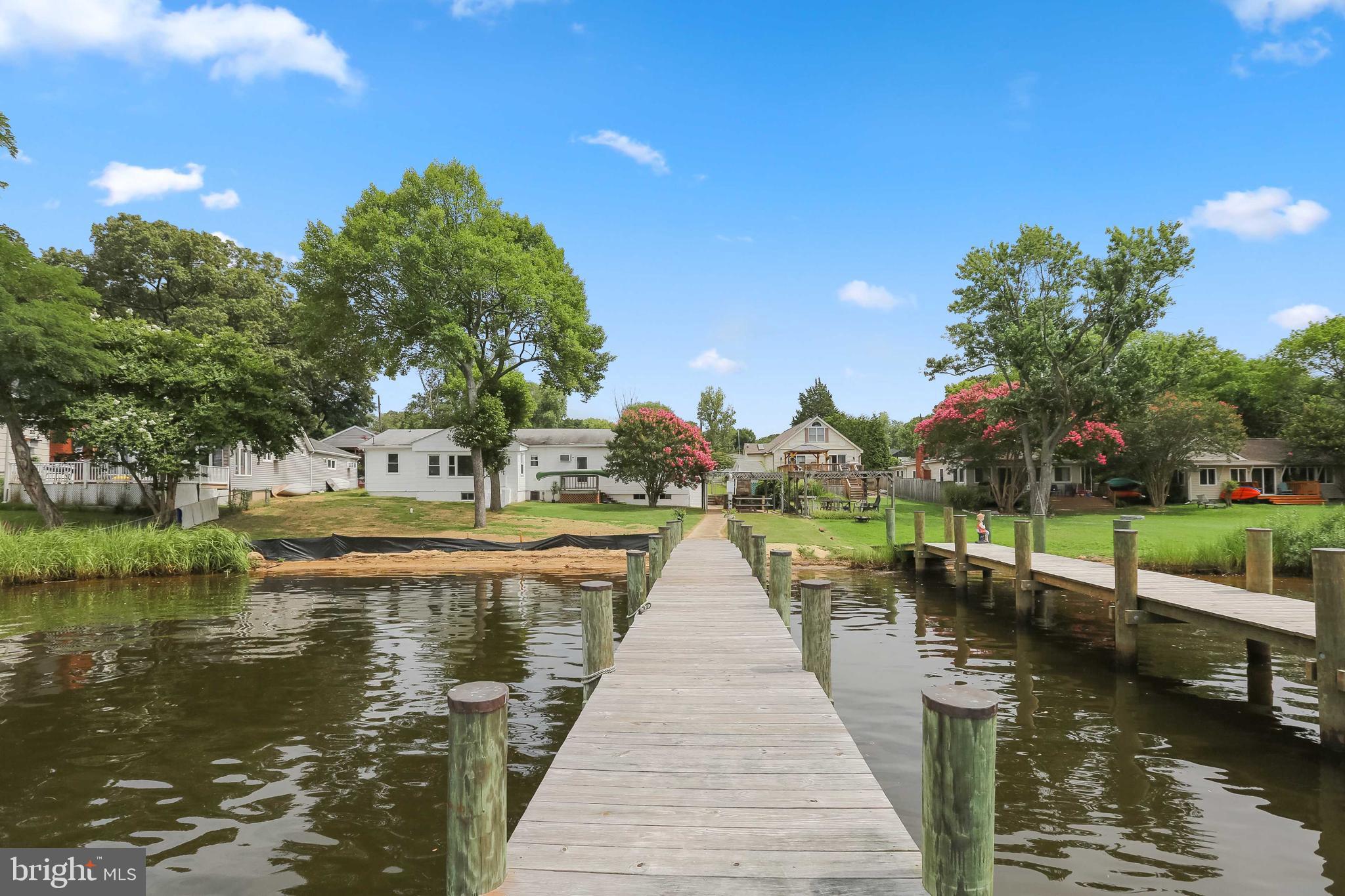 This five bedroom two bathroom rancher with enormous yard and detached carport with covered garage sits on 78 feet of water front. In law suite attached and you could live in one side and rent out the other. Bring any boat into the private dock with 6 feet of water clearance. This home has an outdoor bathhouse and patio with fixed grill and covered seating for entertainment. Cast a net from your own private beach or walk your private pier at sunset. The pier has recently been rebuilt with new treated lumbar. This home even has the potential to build an entire second level which would take the home from 2,011sqft of living space to 4,022+/-. With such and enormous flat yard the possibilities of home improvement are endless. Whether you dream of pool with patio or additional covered garage with rooms on the second level you’ll have plenty of space to improve on this large plat of prime water front real estate.