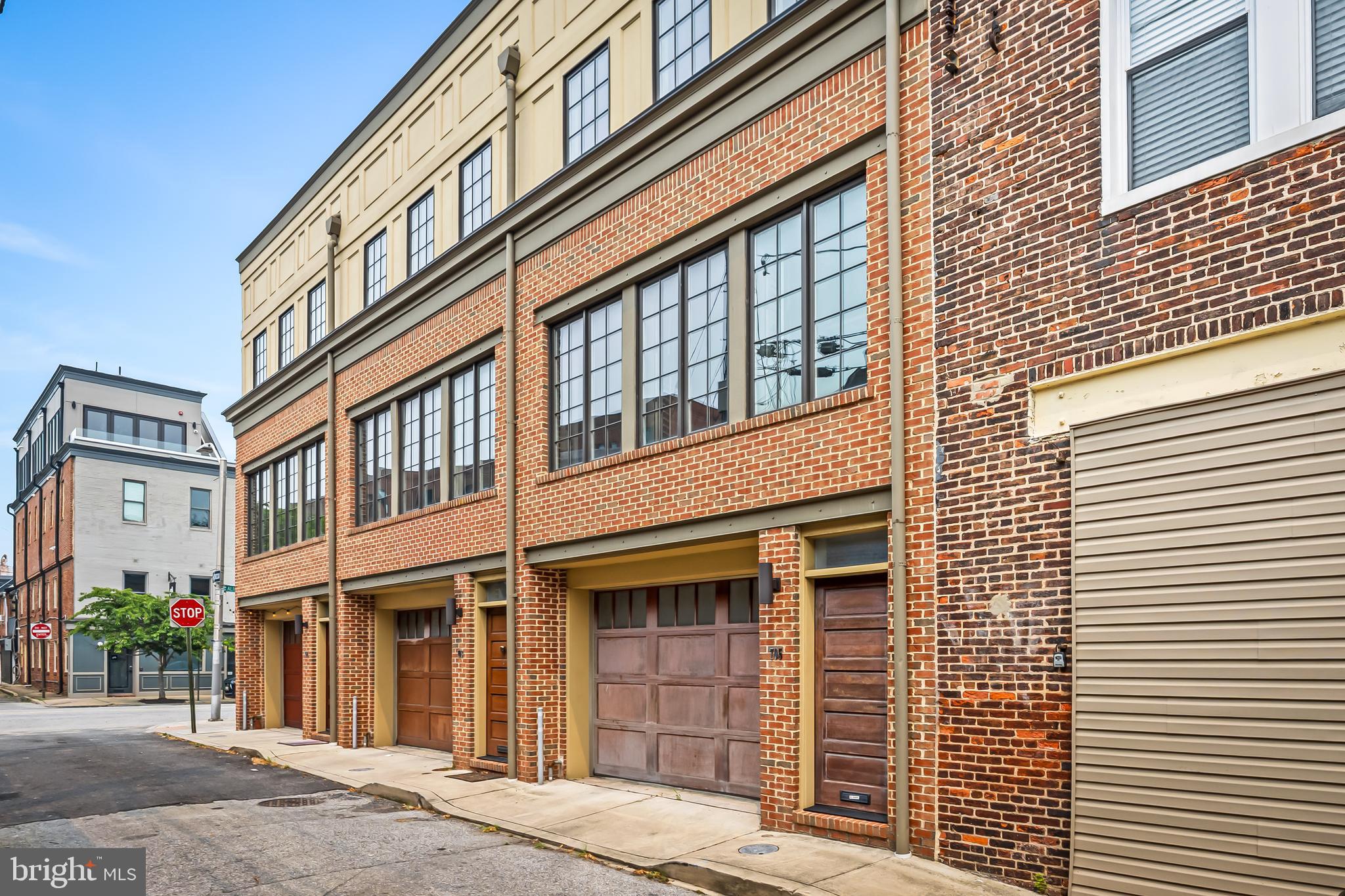 Industrial modern with the comforts of home. You will love this loft-style contemporary townhome in the heart of historic Fells Point WITH ATTACHED GARAGE PARKING and phenomenal rooftop deck. Built in 2015, this gorgeous townhouse looks like a brand new home and boasts a beautiful Gourmet Kitchen with 6-burner commercial range, granite countertops & large island completely open to the spacious Living Room. Other noteworthy details include energy-efficient tankless water heater, custom steel stairs and rails, random-width wood floors, wood garage & entry doors, exposed brick, and study loft. Each upper floor has a bedroom and full bathroom, making it a perfect abode for guests/office/roommates. Spiral stairs lead to the massive and level rooftop deck with cityscape views and room for entertaining, lounging or dining al fresco. The attached garage is ideal for one large SUV and  bonus storage space, or two smaller vehicles. All within walking distance to  the many wonderful shops and restaurants all around Baltimore's fabulous waterfront communities of Fells Point and Canton.