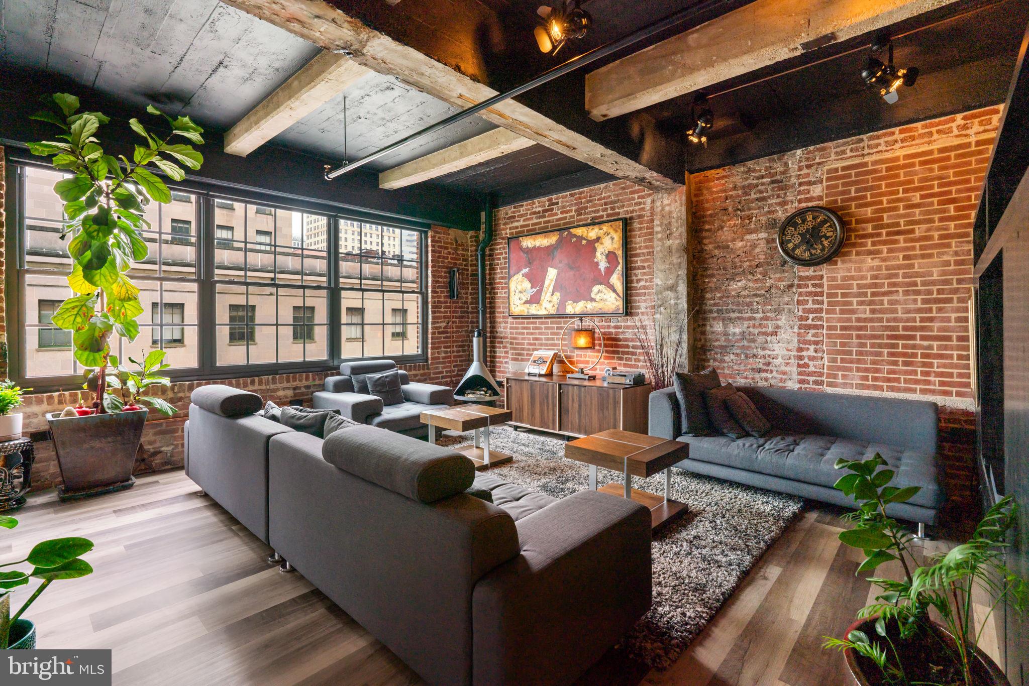 Discover a condo unlike any other in the heart of Downtown Baltimore—a dramatic fusion of design, technology, and luxury living. This 2-bedroom residence with dual primary suites isn’t just smart, it’s brilliantly intuitive. Imagine programming your shower’s temperature and lighting before you even open your front door, or walking into music, climate, and ambiance already set to your preferences. Brilliant Smart Home controls and an integrated Sonos system create a seamless experience throughout, while floor-to-ceiling windows frame breathtaking views of Baltimore City Hall. Every detail has been elevated: custom barn doors, waterproof laminate flooring, a built-in laundry center, and sleek new Samsung appliances. Both ensuite baths are spa-level retreats with smart bidet toilets, heated floor in one bathroom, custom lighting, and a fully reimagined Onsen-inspired wet bath with Moen automated shower and ceiling-fill garden tub. Industrial chic finishes—exposed concrete, refinished pipes, and preserved brick—blend with modern touches like custom closets, smart blinds, a gel fuel fireplace, and upgraded air systems. And for the ultimate convenience, a deeded garage space big enough for two cars with 2 Level 2 EV charger awaits. This is more than a condo—it’s a lifestyle, engineered for the future.