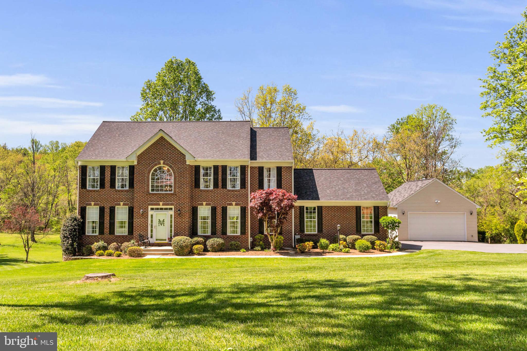 Welcome to this beautifully maintained custom-built home, thoughtfully designed and constructed in 2002 and nestled on a serene and spacious 5 acre lot.  This property offers the perfect blend of quality craftsmanship, privacy, and pride of ownership!  From the moment you arrive, you'll appreciate the attention to detail and care that has gone into this exceptional home and property.  The two level detached garage was added in 2006 and offers 4 additional garage spaces.  The stunning 2 story foyer sets the tone for the rest of the house - formal sophistication and comfortable charm.  The main level features formal living and dining rooms, an open family room with gas fireplace and a private office with amazing views of the yard! The kitchen has a cozy center island with breakfast bar, huge pantry, upgraded appliances (the icemaker even makes craft ice cubes!), and a walkout to the 16'x21' Timbertech deck, perfect for entertaining or simply taking in the peaceful natural surroundings. The primary suite offers two large walk in closets and the bathroom remodeled in 2018 exudes a spa-like ambiance.  The lower level has a rec room, bar area, lots of space for storage, space for rooms, full bath rough in and a convenient level walk out to the picturesque back yard.   Notable updates include new roof and gutters in 9/2024, new lower level carpet and paint 3/2025, Lennox heat pumps 2016 (main) & 2019 (upper), upper level bathroom remodels 2018, refinished hardwood floors 5/2021, carpet replaced throughout the house 5/2021, driveway and parking pad resurfaced 7/2020,  whole home reverse osmosis water system 12/2019, garbage disposal 2025...  with countless features and upgrades, this home truly has to be seen to be fully appreciated!