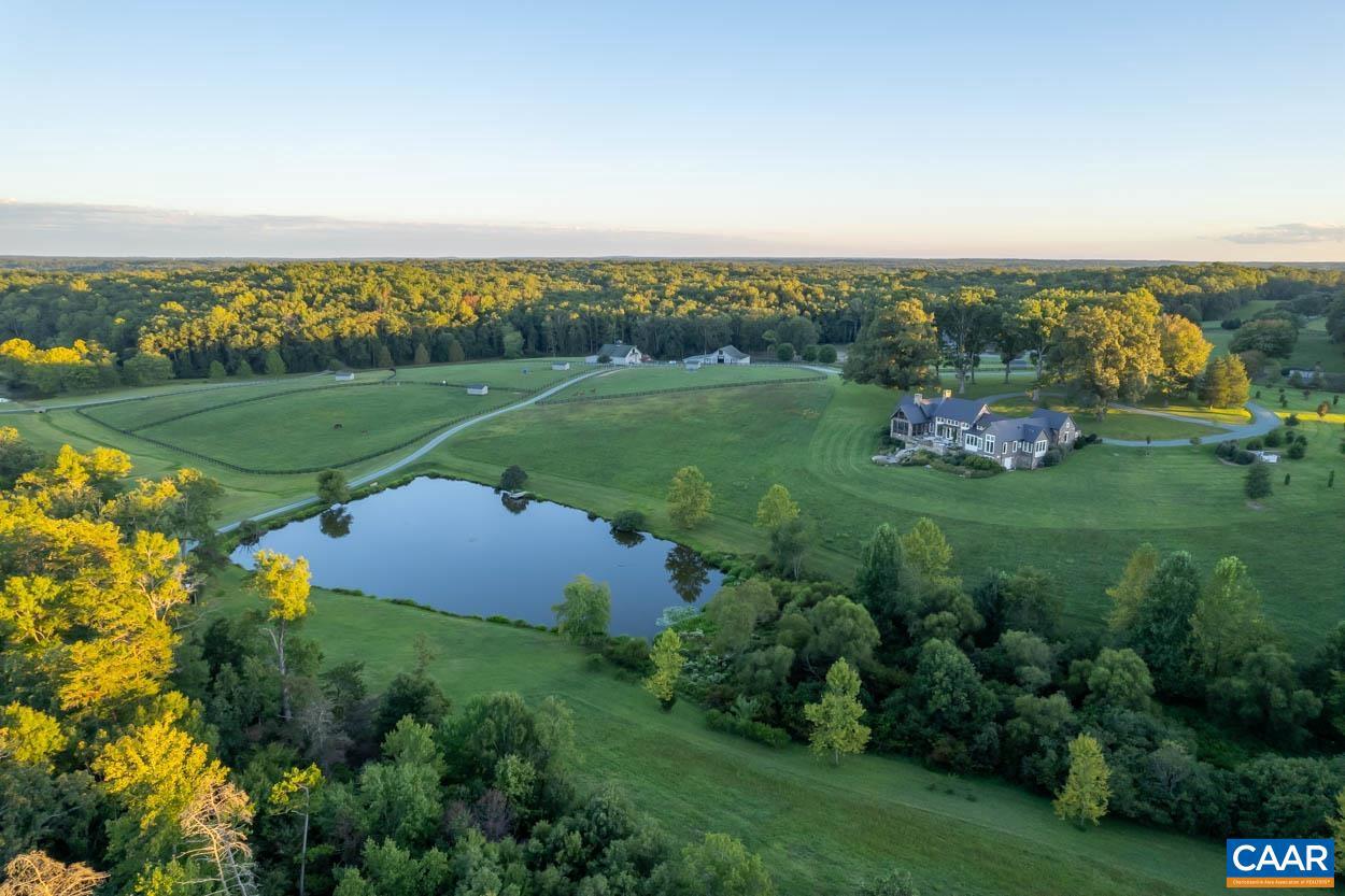 Located just outside Charlottesville and just over 15 minutes to town, is a truly impressive estate. Situated on 314 pristine acres not under easement with two large ponds connected by a bubbling brook. The ultimate horse property with 11 paddocks, 24 stall stable with indoor riding ring, as well as 300x150 outdoor ring. A tree lined driveway leads you through the farm and to the main residence. The Uhler built 4414 SQFT home is impressive in its presentation taking advantage of pastoral and water views. Once inside, you will find a stunning great room with floor to ceiling windows, French Oak floors, a beautiful chef's kitchen, and a dining room, all encapsulated in an open floor plan. The kitchen and pantry have ample storage, with top of the line appliances, limestone counters, and farm sink. The primary suite has two separate walk in closets, fireplace, private porch, and primary bath. Large guest-suite with full, ensuite bathroom. Cozy home office with built in bookcases. A full size laundry room with blue stone floor features your own dog shower for at home grooming. 2.5 car garage with EV charger. Two solar fields for power. The stable also has its own 2 bed/2 bath apartment. Almost all paddocks have waterers.,Maple Cabinets,Painted Cabinets,Solid Surface Counter,Exterior Fireplace,Fireplace in Great Room,Fireplace in Master Bedroom