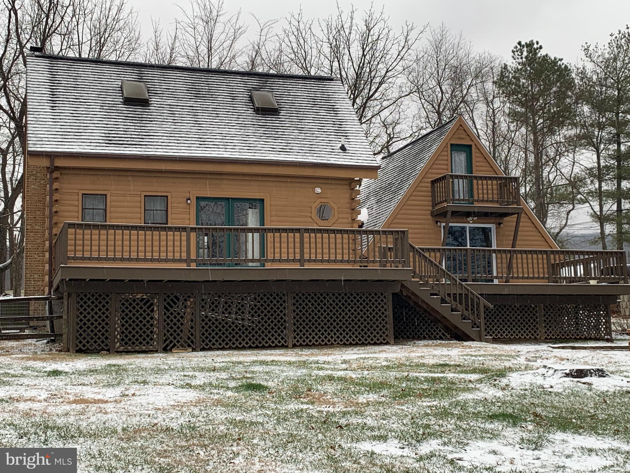 RARE OPPORTUNITY to live in your own cozy cabin in the hills of West Virginia overlooking the Potomac River Valley with the twinkle of beloved Charles Town beyond.   As a primary home or an escape to WV, this log home is as fun as it gets to live on over 1 fenced acre in an all log and wood!  Nestle by the wood stove in the living room or capture storytime while cooking warmed by the pellet stove in the wood floored entry.   Incredibly charming with the warmth living on the land brings.  Modern amenities like a full kitchen, washer, dryer all convey.   The two spiral staircases are efficient use of space and a unique feature leading to two amazing loft bedrooms.  The smaller loft bedroom features wood floors and a balcony.  The primary loft is a beautiful exposed log and beam bedroom with raised wooden floor.   A passage to bring furniture to the loft is conveniently  available.  You will love the expansive ceiling, raised floors and natural light in this private loft. 
Situated on over an acre with no restrictions, you may bring your chickens or other furry or feathered friends and channel your inner pioneer with your own garden and trees. Interior photos coming soo, don't wait to book your tour.