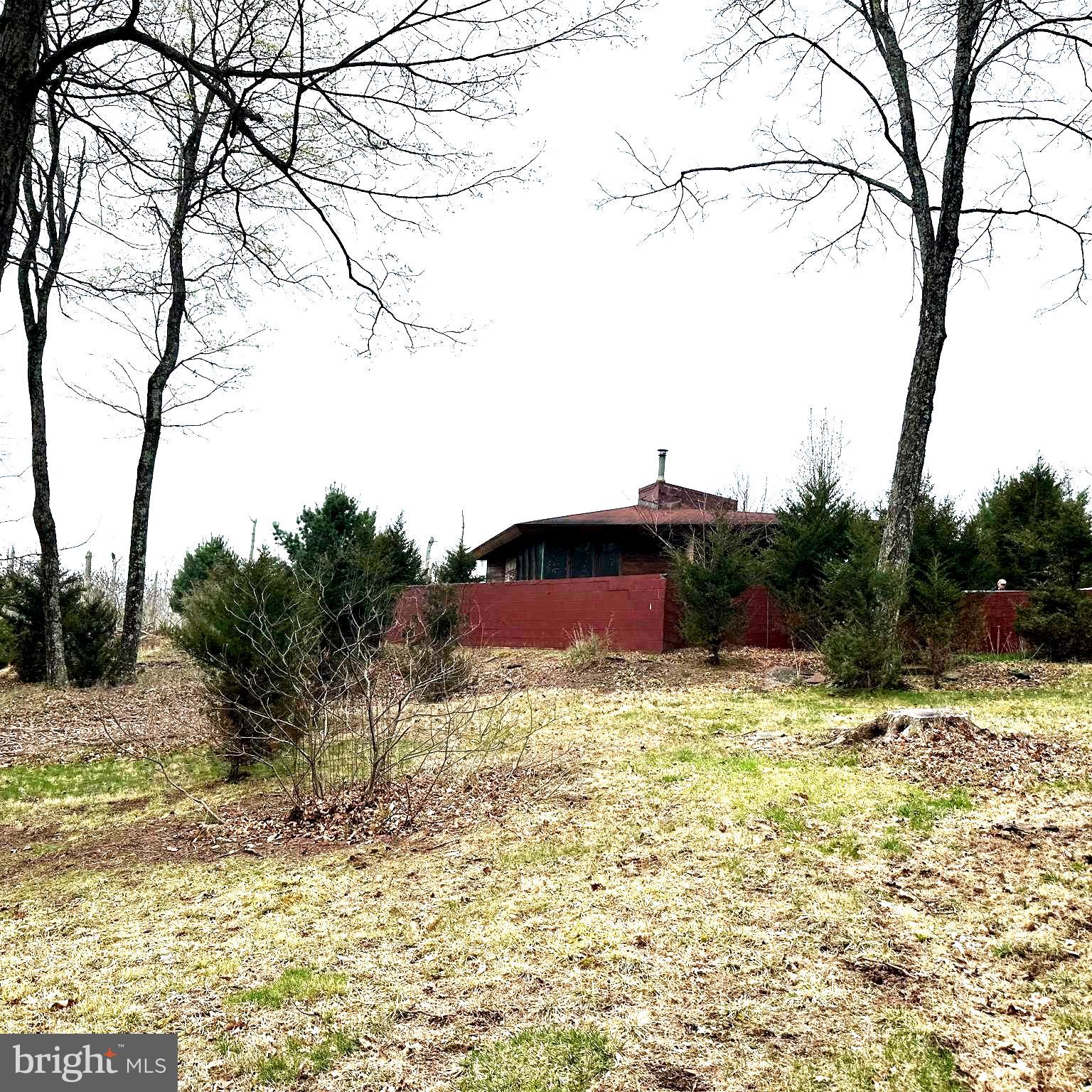 Welcome to your little slice of heaven where you truly can get away from it all in the woods of bucolic Bucks County!  This mostly wooded property spanning nearly 12 acres is accessed via a long winding dirt driveway that crosses a small stream so owning an suv or 4 wheel drive vehicle is a must unless improved.  Make your way up the hill to the house and you'll be amazed at the serenity and beauty of the location.  The current dwelling is a 1 bedroom 1 bathroom home constructed based upon an original Frank Lloyd Wright design.  To say the home is unique would be an understatement.  Update and make it your new home, rental or weekend get away.  Or design and construct an entirely new home and perhaps the current dwelling becomes the pool house?  So much potential here...priced to move fast.  Estate sale.  Do not enter property grounds or driveway without an appointment.