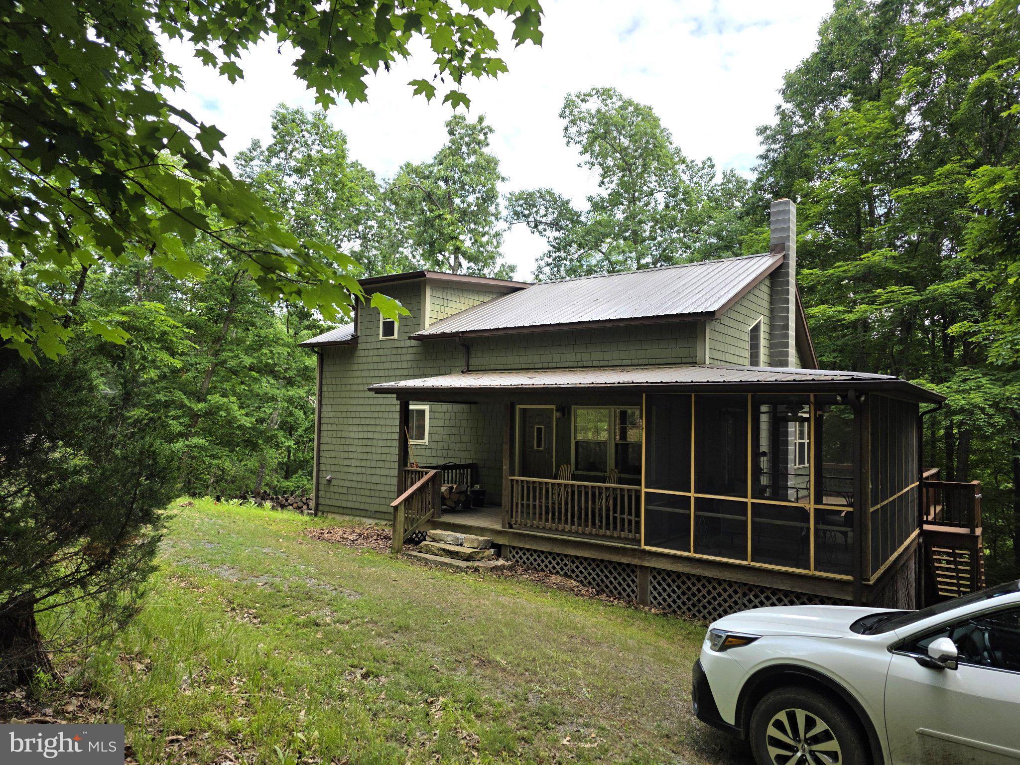 Located minutes from the quaint town of Franklin in the Buck Ridges community, this charming cabin-style home offers a perfect blend of comfort and nature. Built in 2008, with sturdy construction of 6" walls, this detached residence boasts 3 spacious bedrooms and 3 bathrooms, providing ample space for relaxation and privacy. The open floor plan seamlessly connects the living and dining areas, enhanced by warm wood floors and a cozy Jotul wood stove, creating an inviting atmosphere for gatherings. The galley kitchen is well appointed with natural light and ample counter space. Enjoy the convenience of a main floor laundry off of the galley kitchen and a primary bedroom with a walk-in closet and en-suite bath, ensuring everyday ease. Upstairs, you'll find a cozy reading nook with a wall of bookshelves. From there, you'll enter a bedroom w/seating area and en-suite flooded with natural light and lots of unique touches. The fully finished basement also has plenty of natural light and features another living space with adjoining bonus room. Down the hall you'll find a workshop/utility area, bath and the downstairs bedroom. From the basement, you can walk out to the beautiful stone patio where you can sit and enjoy the views of nature and passing wildlife. The 10 acre property is beautifully secluded near the end of a cul-de-sac, backing to trees and offering a peaceful rural setting. There are additional outdoor spaces to enjoy, including a screened-in porch and adjoining deck, inviting you to relax and unwind. Experience the harmony of nature and modern living in this delightful home, where every detail has been thoughtfully crafted. It's the perfect retreat from the hustle and bustle, yet still close enough to enjoy local amenities where you can enjoy swimming, bowling, our popular coffee shop, drive-in movies, fishing and hiking. Just a short 30 minute drive West will take you to Seneca Rocks Recreation area where you can enjoy rock climbing, hiking, caverns, etc. Drive an hour to the East and you can be in Harrisonburg, VA near Interstate 81 for ease of travel.