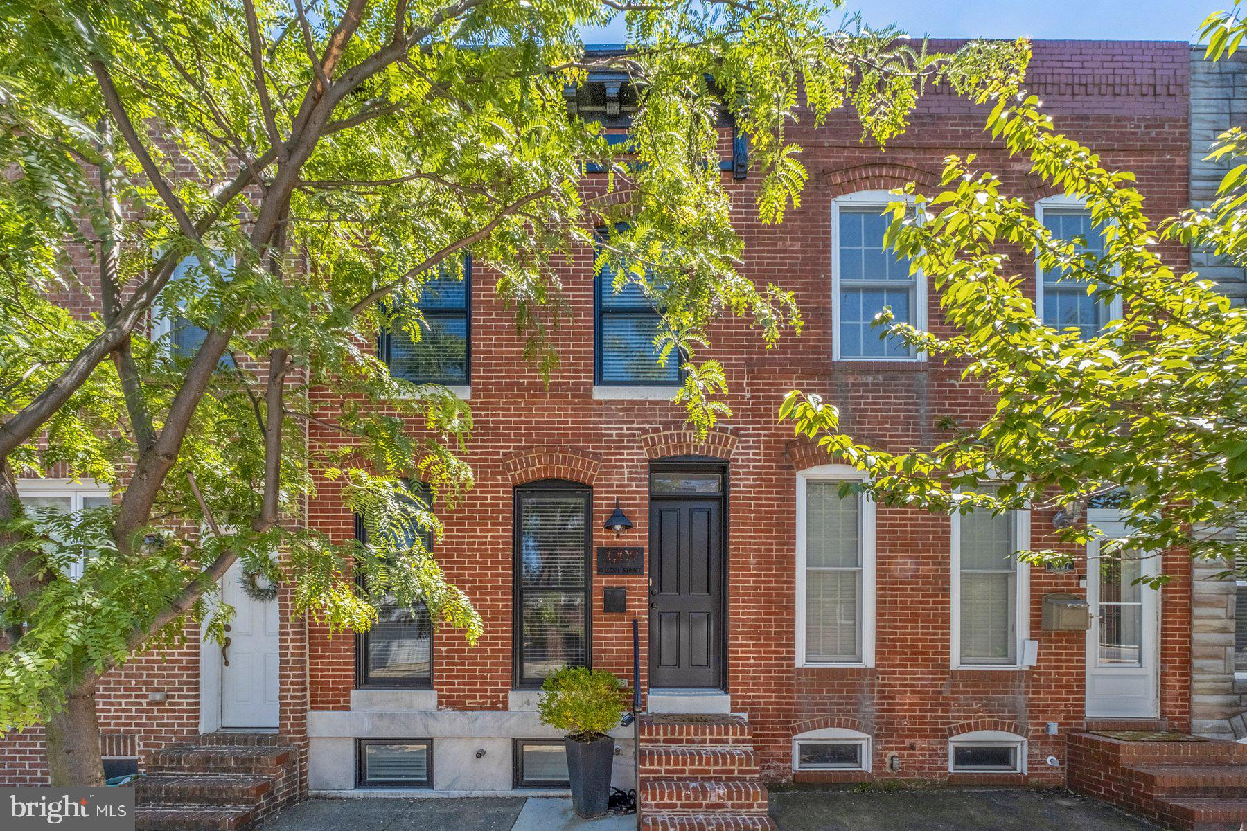 Stunning & beautifully maintained move-in ready 3BR/3BA classic Baltimore brick home located on a tree-lined street in the desirable neighborhood of Canton.  Make your way to the front door and step into this stylish home featuring exposed brick wall, crown moldings, an open main floor plan, recessed lighting, stunning wood flooring and a whole home audio system.  The main floor boasts a spacious living room open to the dining room and a glamorous kitchen.  The kitchen features abundant cabinetry with under cabinet lighting, stainless steel appliances, granite countertops with a complementing tile backsplash, a stainless-steel sink under a window, and a center island with pendant lights and breakfast seating. The exposed brick wall and luxury flooring carry up to the second floor offering a spacious secondary bedroom, a full bath, and an oversized primary bedroom with double closets, a private full bath with a walk-in shower, and access to the two-tier roof-top deck.  Step outside and take the stairs up to a private roof-top deck that offers stunning views of the city sky-line and waterfront.  The lower level is finished, featuring a primary sized bedroom, a full bath, laundry, a large carpeted family room, and storage.  From the kitchen step out to a covered stairway leading to an open patio with off street parking pad.  This move-in-ready home with brand new hvac system (just installed) is ideal for any new homeowner and is located near to shopping, restaurants, and commuter routes.