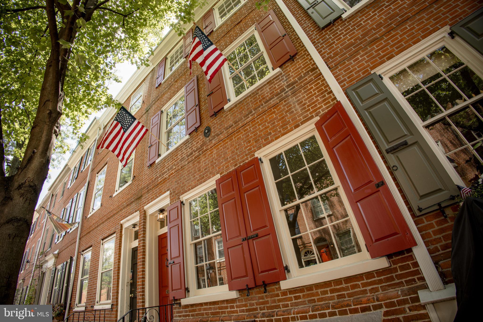 Set on one of Society Hill’s most coveted blocks, this masterfully restored historic townhome developed by Baker Street Partners seamlessly blends timeless Philadelphia character with refined modern luxury. Behind its classic red brick façade and iconic shutters, a light-filled interior unfolds with exceptional craftsmanship, elegant millwork, and designer finishes throughout.  The gracious living room is anchored by a beautifully restored wood-burning fireplace, soaring ceilings, intricate molding and oversized windows that bathe the home in natural light.  The chef’s kitchen is a true showpiece, featuring custom cabinetry, stainless steel appliances and pot filler, designer hardware and a statement ILVE range beneath a custom hood. Every detail has been carefully curated to balance functionality and timeless style.  The luxurious primary suite (don't miss the laundry chute) offers a serene retreat with spa-inspired bath finishes, a custom wood vanity and a stunning glass-enclosed shower with custom tile and dual shower heads.   The third floor features another spacious bedroom, a bathroom with a double sink vanity and a bonus room that can either be a home office/nursery/oversized walk-in closet.    The top floor loft is soaked in natural light and the exposed wood beams create warmth and sophistication.  The walk-out lower level offers historic character and is anchored by the home's original brick flooring, brick fireplace, custom built-in shelves and entertainment center and an arched wine alcove which creates a distinctive architectural focal point.  This floor is complete with a powder room and laundry room.  The tree-filled backyard with red brick walls is unusually deep for the neighborhood and is perfect for outdoor entertaining, al fresco dining and/or gardening.  Located on the prestigious 500 block of Delancey Street, this exceptional residence places you steps from Society Hill’s charming tree-lined streets, award-winning restaurants, historic landmarks and neighborhood parks. A rare opportunity to own a turnkey historic home where architectural significance meets modern living in one of Philadelphia’s most desirable neighborhoods.