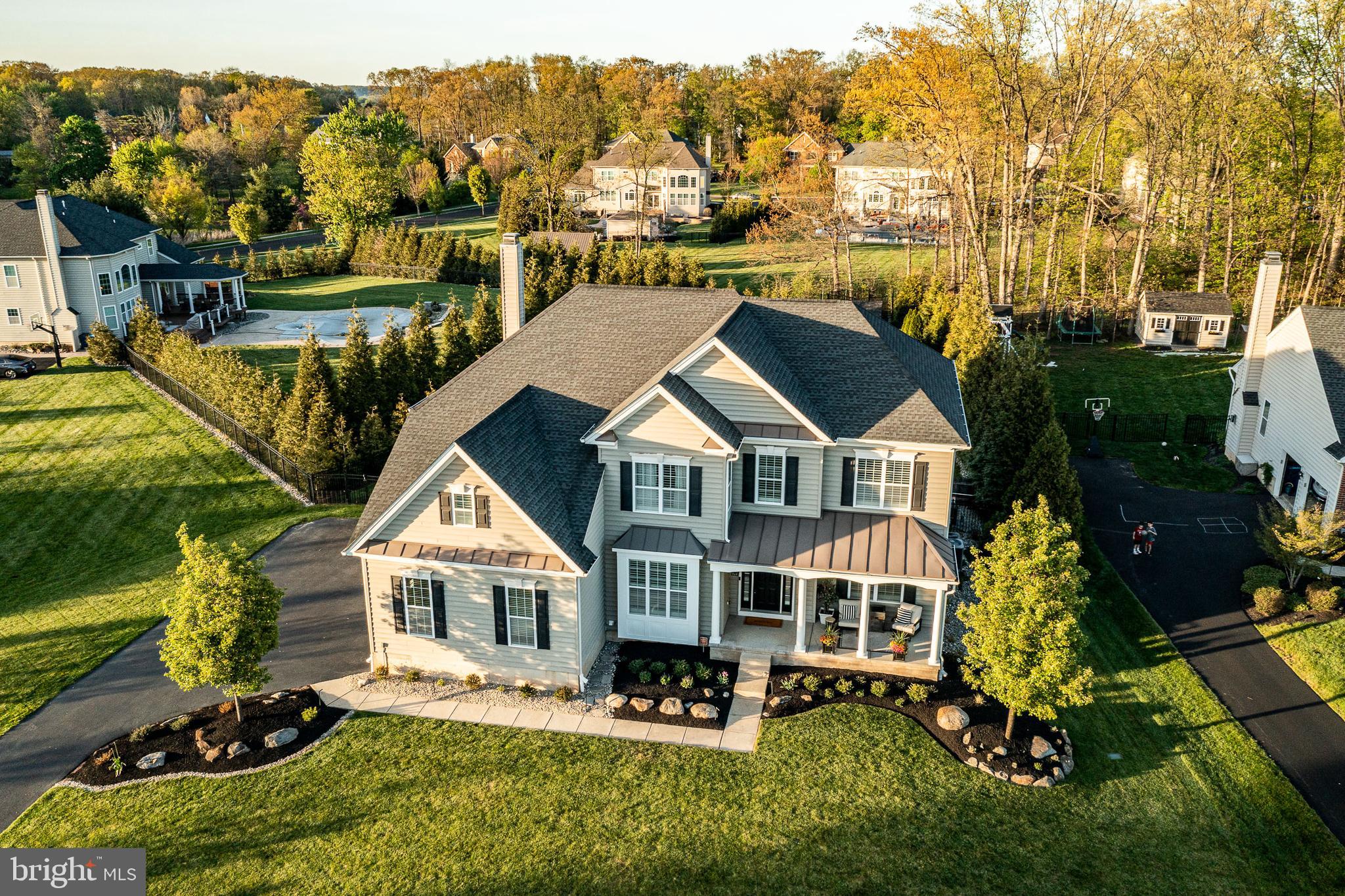 Set on nearly half an acre in Hilltown Township's Coventry Meadows community, this 2015-built traditional home offers over 5,400 square feet of thoughtfully designed living space where every detail has been considered and every finish elevated.
The heart of the home is a showstopping gourmet kitchen anchored by a 10-foot quartz island, walk-in pantry, under-cabinet lighting, and high-end stainless appliances — all flowing seamlessly into a sun-filled breakfast area with skylight and sliding doors to the outdoor retreat beyond. The dining room's custom wood beams frame the open-concept connection to a soaring two-story family room with stacked stone gas fireplace and custom shelving. Two custom staircases — both front and rear — are finished with modern black wrought iron railings, setting a sophisticated tone as you move through the home.  New hardwood floors, fresh paint and a main-floor office with glass doors round out the main level.
Upstairs, the primary suite is a true sanctuary. A generous bedroom with a dedicated sitting area gives you space to unwind, while a custom walk-in closet. The en suite bath is nothing short of stunning, wrapped in rich English walnut millwork with high-end finishes at every turn. It's the kind of space that makes you forget the rest of the world exists.
Three additional bedrooms — one with its own private bath, two sharing a Jack & Jill — offer generous dimensions and built-in closet systems.
The fully finished lower level adds exceptional versatility: LVP flooring, a full kitchen, full bath,  built-ins, and a flexible bonus room perfectly suited for guests, multi-generational living, or a private home office suite.
Outside, the backyard is a genuine resort: heated pool with designer lighting, hot tub, stamped concrete patio with natural gas fireplace, and a covered lounge area with TV — all managed via a smart home system from your phone. A 3-car garage with mezzanine storage, whole-home built-in speaker system, two-zone HVAC with newer A/C units, water softener with reverse osmosis, central vacuum, and new pool equipment complete this turn-key offering.
This is Bucks County luxury living — refined, functional, and ready for its next chapter.