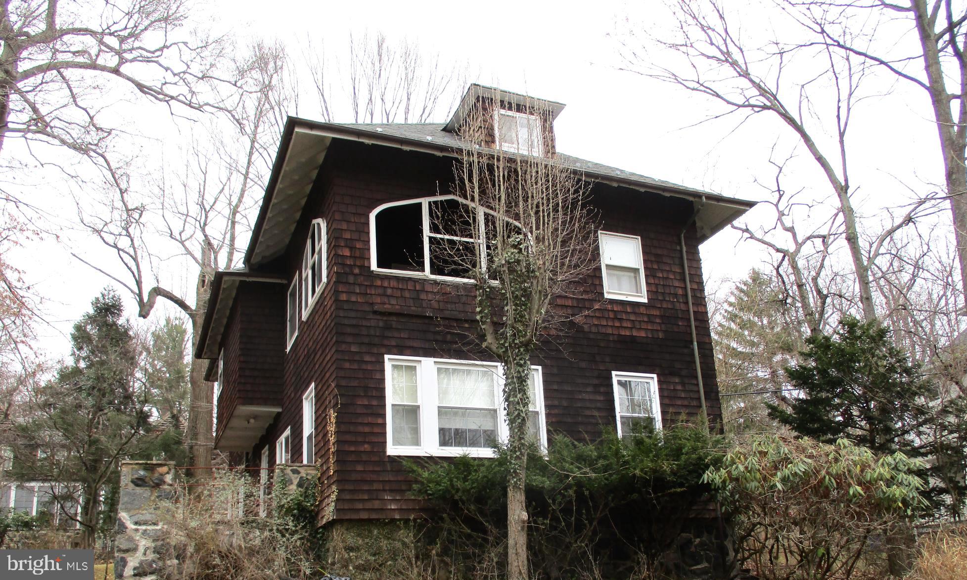 Spacious 1908 shingled style craftsman.  This home is filled with many original features.  Beautiful hardwood floors, built-in bookcases.  Spectacular wood trim throughout, wood bannisters, some replacement windows, sleeping porch, large butlers pantry with sink.  Bring your ideas, live in this while you bring it back to it's glory.  Lovely large wooded lot.  Updated 50 year architectural shingle roof.  All of this and moments from Gwynns Falls Trail.  Very active neighborhood.   Please include an "As-is" addendum.