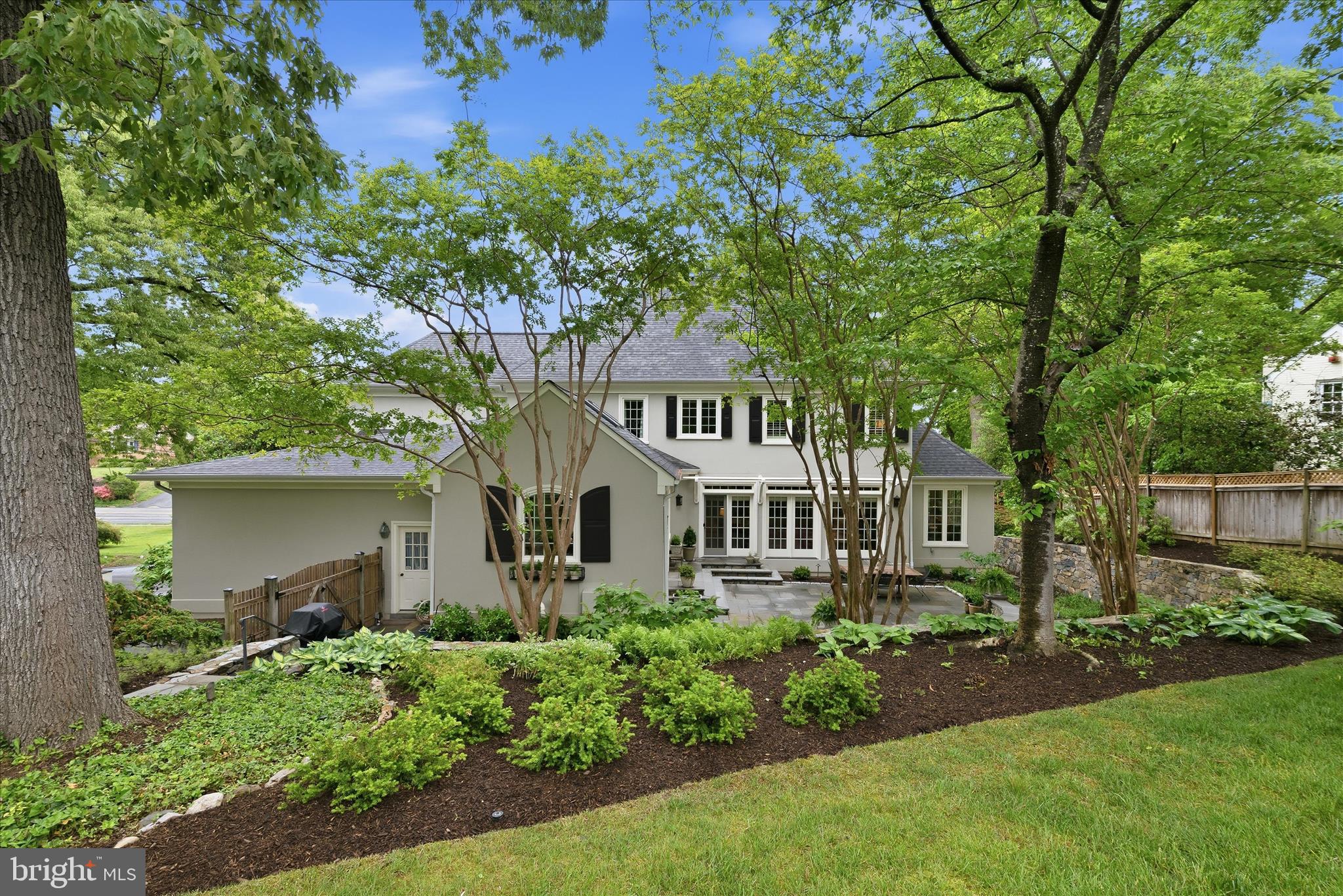 OPEN SUN 6/7 2p - 4p. Sited beautifully in the coveted Old Glebe neighborhood, 3824 Military Road is a Gruver Cooley custom home that fully embraces its nearly two-thirds acre setting—offering a rare combination of presence, privacy, and accessibility with close proximity to  the George Washington Memorial Parkway.

The main level is where this home truly shines, designed with both elegance and livability in mind. A classic center hall foyer welcomes you with a graceful staircase, flanked by well-proportioned living and dining rooms that create a sense of symmetry and intention. From there, the home unfolds into a series of interconnected spaces ideal for both everyday living and entertaining.

The living room transitions seamlessly into a charming sunroom with its own fireplace—an inviting retreat that opens to a covered porch, extending the living space outdoors. At the heart of the home, the family room makes a striking impression with its floor-to-ceiling windows and dramatic stone fireplace. Flooded with natural light, this space is designed to gather, with French doors that open directly to the flagstone patio and expansive backyard, creating a seamless indoor-outdoor connection that defines the main level experience.

The family room flows effortlessly into a spacious breakfast area and a bright, outward-facing kitchen. Anchored by a center island, the kitchen is thoughtfully oriented to capture views of the landscaped backyard and is appointed with high-end appliances, including a Sub-Zero refrigerator and Thermador cooktop. Whether hosting or enjoying a quiet morning, the entire rear of the home is designed to maximize light, views, and access to the outdoors.

Throughout the main level, thoughtful details add both function and character—custom built-ins, a dedicated office with tailored cabinetry, a convenient laundry room, and a flexible ensuite bedroom ideal for guests or multigenerational living. Dual staircases enhance flow and accessibility, while integrated storage keeps everything effortlessly organized.

The backyard is a standout feature—private, expansive, and beautifully landscaped to create a true outdoor retreat. Mature plantings frame the space, offering a sense of seclusion that is increasingly rare in this close-in location. The flagstone patio serves as a natural extension of the home, perfect for dining, entertaining, or relaxing, and is complemented by elegant stone sitting walls and substantial retaining walls with integrated steps leading to the upper yard.

The upper level of the backyard offers exceptional versatility, with ample space for a future pool, playset, or additional outdoor living features. The thoughtful terracing not only enhances usability but also adds architectural interest to the landscape design, making the outdoor space as intentional as the interior.

Together, the main level and backyard create a cohesive living experience—one that balances openness with comfort and makes the most of both the home’s layout and its remarkable setting.

Upstairs, the home offers five additional bedrooms, including a spacious primary suite with dual closets and a well-appointed ensuite bath. Two bedrooms share a Jack-and-Jill bath, while two others are served by a hall bathroom. The lower level provides additional flexibility with a game and media area, play space, and abundant unfinished storage ideal for hobbies or future expansion.

Completing the property are two separate garages and an unbeatable location within the Yorktown, Williamsburg, and Jamestown school pyramid. Just moments from Gulf Branch Nature Center, scenic trails, and the Potomac River, this home offers a rare opportunity to enjoy both natural beauty and everyday convenience in one of Arlington’s most sought-after neighborhoods.