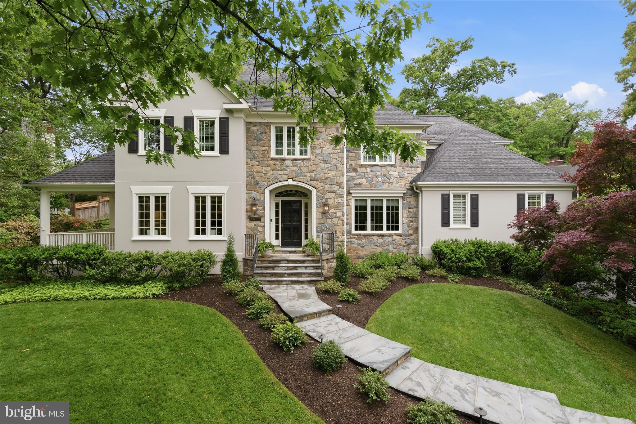 OPEN SAT 5/23 1p - 3p. Sited beautifully in the coveted Old Glebe neighborhood, 3824 Military Road is a Gruver Cooley custom home that fully embraces its nearly two-thirds acre setting—offering a rare combination of presence, privacy, and accessibility with close proximity to  the George Washington Memorial Parkway.

The main level is where this home truly shines, designed with both elegance and livability in mind. A classic center hall foyer welcomes you with a graceful staircase, flanked by well-proportioned living and dining rooms that create a sense of symmetry and intention. From there, the home unfolds into a series of interconnected spaces ideal for both everyday living and entertaining.

The living room transitions seamlessly into a charming sunroom with its own fireplace—an inviting retreat that opens to a covered porch, extending the living space outdoors. At the heart of the home, the family room makes a striking impression with its floor-to-ceiling windows and dramatic stone fireplace. Flooded with natural light, this space is designed to gather, with French doors that open directly to the flagstone patio and expansive backyard, creating a seamless indoor-outdoor connection that defines the main level experience.

The family room flows effortlessly into a spacious breakfast area and a bright, outward-facing kitchen. Anchored by a center island, the kitchen is thoughtfully oriented to capture views of the landscaped backyard and is appointed with high-end appliances, including a Sub-Zero refrigerator and Thermador cooktop. Whether hosting or enjoying a quiet morning, the entire rear of the home is designed to maximize light, views, and access to the outdoors.

Throughout the main level, thoughtful details add both function and character—custom built-ins, a dedicated office with tailored cabinetry, a convenient laundry room, and a flexible ensuite bedroom ideal for guests or multigenerational living. Dual staircases enhance flow and accessibility, while integrated storage keeps everything effortlessly organized.

The backyard is a standout feature—private, expansive, and beautifully landscaped to create a true outdoor retreat. Mature plantings frame the space, offering a sense of seclusion that is increasingly rare in this close-in location. The flagstone patio serves as a natural extension of the home, perfect for dining, entertaining, or relaxing, and is complemented by elegant stone sitting walls and substantial retaining walls with integrated steps leading to the upper yard.

The upper level of the backyard offers exceptional versatility, with ample space for a future pool, playset, or additional outdoor living features. The thoughtful terracing not only enhances usability but also adds architectural interest to the landscape design, making the outdoor space as intentional as the interior.

Together, the main level and backyard create a cohesive living experience—one that balances openness with comfort and makes the most of both the home’s layout and its remarkable setting.

Upstairs, the home offers five additional bedrooms, including a spacious primary suite with dual closets and a well-appointed ensuite bath. Two bedrooms share a Jack-and-Jill bath, while two others are served by a hall bathroom. The lower level provides additional flexibility with a game and media area, play space, and abundant unfinished storage ideal for hobbies or future expansion.

Completing the property are two separate garages and an unbeatable location within the Yorktown, Williamsburg, and Jamestown school pyramid. Just moments from Gulf Branch Nature Center, scenic trails, and the Potomac River, this home offers a rare opportunity to enjoy both natural beauty and everyday convenience in one of Arlington’s most sought-after neighborhoods.
