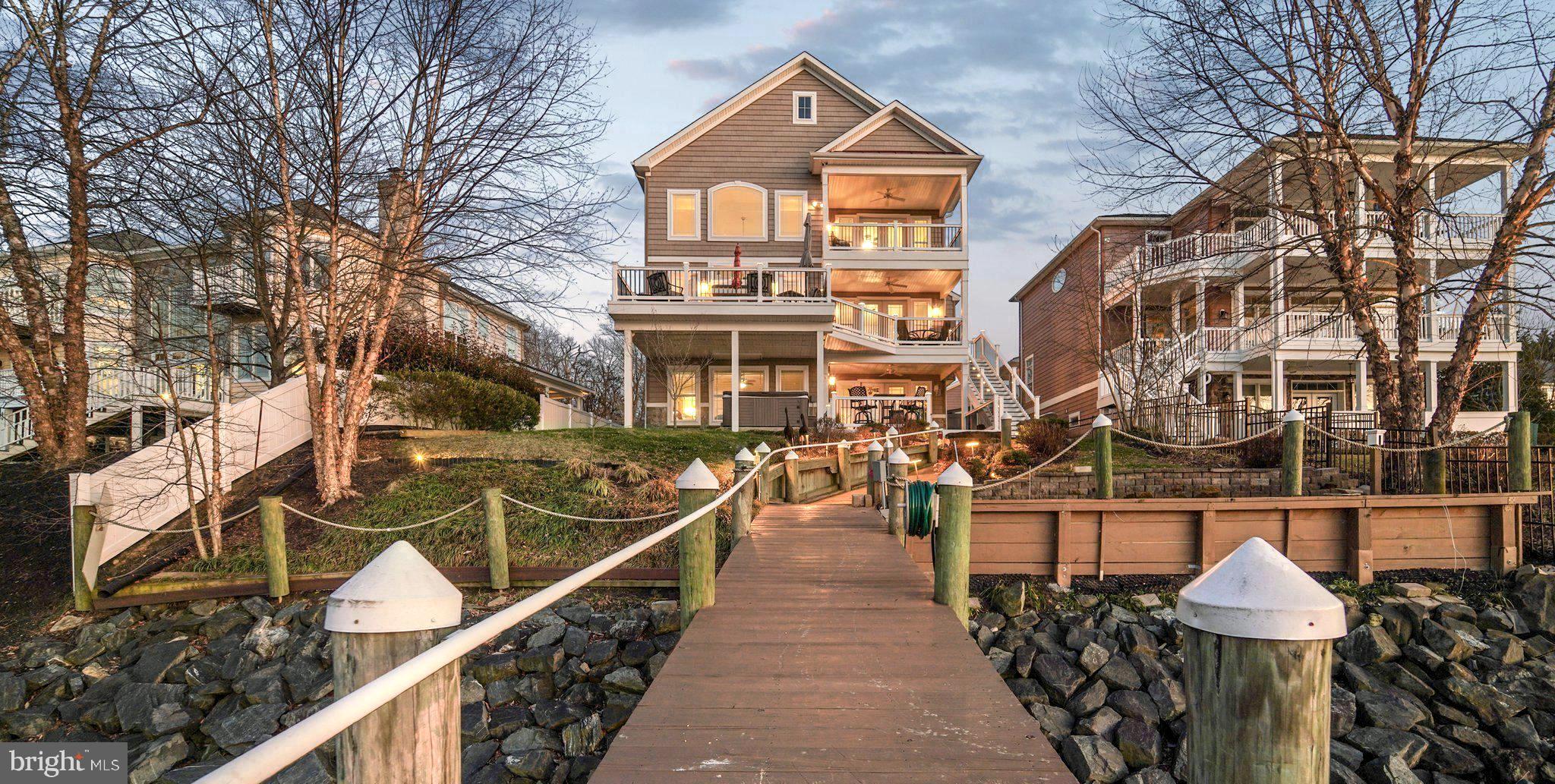 ***NO FLOOD INSURANCE REQUIRED***  Explore the beauty of the waterways from Norman Creek to the scenic Chesapeake Bay!  Whether you are boating, fishing, or simply embracing the serene creekfront ambiance, this property truly embodies the ultimate coastal lifestyle. Don’t miss this rare chance to secure a piece of waterfront paradise on a unique peninsula, surrounded mostly by new construction and picturesque woodlands. This custom-built 3-story, 10-year-old, 4,900 sq. ft. retreat, situated on an elevated 0.25-acre lot, does not require flood insurance! This remarkable home is designed with both entertaining and relaxation in mind. From every balcony, you will be greeted by breathtaking water views, enhanced by 8-foot doors and 6-Foot windows that invite natural light into every corner of the house. Each level features charming covered porches/decks, and the front facade offers 2 porches and a main level front patio/porch, making entertaining a pleasure—whether on or off the water! Professional boaters will enjoy the 120-foot marine-grade lumber pier equipped with electric power, de-icers, 2 boat lifts, a jet ski lift, a Sun deck, and a floating dock for two jet skis. The beginning of the pier is surrounded by a Rip Rap bulkhead.
As you step inside, you will appreciate the open design with 9Ft ceilings throughout. The 2nd Floor living level offers a breathtaking 2-Story coffered ceiling in the family room, showcasing a stone gas fireplace surrounded by transoms and architecturally designed windows-what a view!. The “heart of the home”? A magazine-worthy professional kitchen with cherry cabinetry, gleaming granite countertops, and Kitchenaid stainless steel appliances! Gleaming Hardwood on the 2nd and 3rd Floors....Manufactured laminate hardwood on the 1st level.  Every space feels intentional and elevated, offering a primary suite on the first level, another on the third level; four total bedrooms, each equipped with an ensuite bath.  The ground Floor has a LL Family Room and Half Bath as well. Want to host a wedding or New Year’s Eve party?  No problem with a wet bar on two levels of the home! It’s a lifestyle, waterfront living re-defined. Opportunities like this don't float by twice- your boat belongs here!    Included in a long list of upgraded options are a 50 Year Shingle Roof, Cat 6 wiring throughout, Hardwood staircases with single-basket wrought-iron balusters, 2 laundry rooms, 2-zone heating with Propane backup controlled by separate thermostats on each floor! 21x21 two-car attached garage, a stamped concrete driveway, a hot-tub deck, and much more.  The address number in the MLS listing map and Google Maps is incorrect (it says 428). The Pin in the MLS Map is correct for 424 Katherine. Please see our features and amenities list in the disclosures.  Check out our interactive video walk-through and Floor Plans!