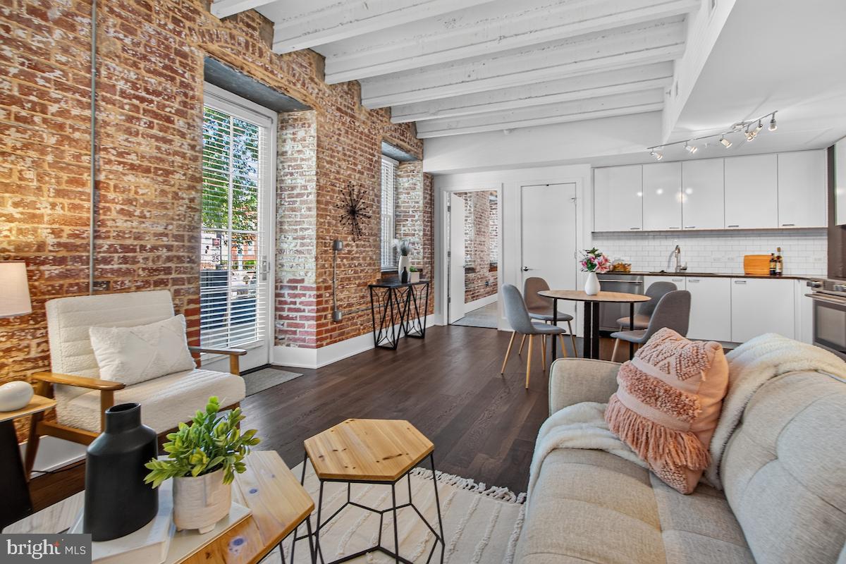 Historic character meets modern design in this exceptional 2-bedroom, 2-bath residence with a private terrace at The Mill, a historically significant building in the heart of Old Town Alexandria. Once the renowned Mount Vernon cotton factory, this iconic structure has gracefully withstood the test of time and was meticulously restored in 2021 into 25 sophisticated, loft-style condominiums.

This residence embodies true loft living with expansive original exposed brick, soaring beamed ceilings, and oversized windows that fill the space with natural light. The open-concept living and dining areas flow seamlessly into a thoughtfully renovated kitchen featuring contemporary cabinetry, stainless-steel appliances, and clean, modern finishes. A rare private terrace extends the living space outdoors, offering a seamless indoor-outdoor lifestyle.

The primary suite is a warm and inviting retreat framed by historic textures, while the second bedroom provides flexibility for guests, a home office, or additional living space. Every detail reflects a careful balance between preserved architectural integrity and modern comfort.

The Mill offers a rare blend of historic character and modern amenities, including secured parking and a boutique, pet-friendly setting. Outdoor amenities extend to a charming adjacent park with beautifully landscaped grounds, inviting seating areas, a BBQ station, and a cozy fire pit, creating a unique extension of the living experience.

Ideally located just moments from Trader Joe’s, Harris Teeter, and the shops and restaurants along King Street, this residence offers both convenience and a distinctive lifestyle in one of Alexandria’s most desirable settings.

A rare opportunity to own a piece of history reimagined for contemporary living.

**VA assumable loan available at an attractive 3.75% interest rate. Reach out for details and eligibility requirements.**