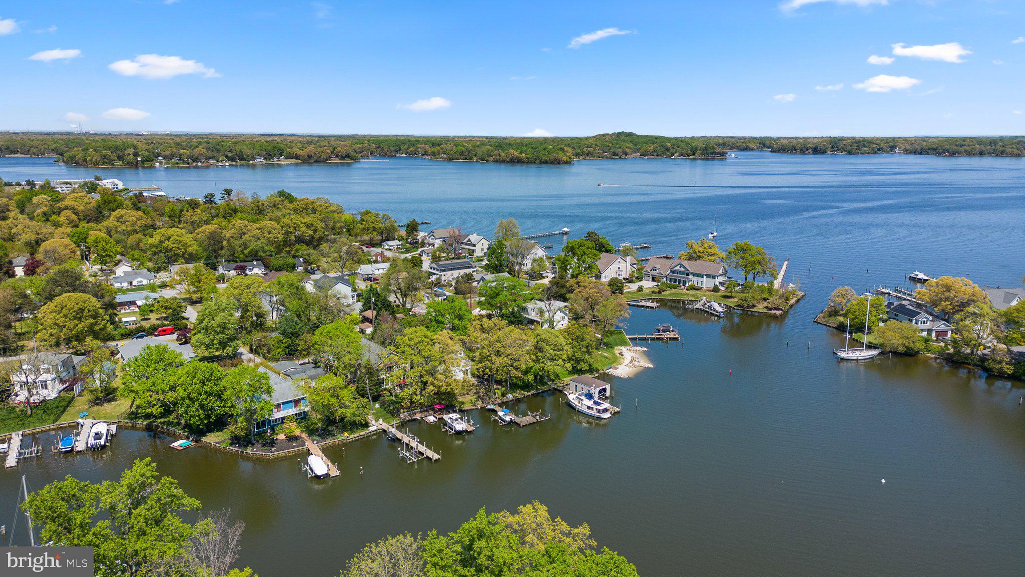 Stunning, custom built Arnold Waterfront in Magothy Manor. Enjoy your private oasis on the protected Spriggs Pond that feeds directly out to the wide open Magothy River. Perfectly designed for entertaining inside or out, every detail of this 4 bedroom 2 full and 2 half bath home has been carefully considered. A stone facade and welcoming front porch flow seamlessly to the front foyer with an open staircase to the upper level and a wide walk way to the open concept great room. A chef's gourmet kitchen with granite counters, stainless steel appliances and a large island with high top bar seating for plenty of guests is open to the dining room and living room beyond. Travel outside to one of 2 screened in porches overlooking the water. A patio with a bar and hot tub will ensure memorable get togethers with family or friends. On the upper level you will find the most relaxing primary retreat with its own private screened porch, spacious en suite bathroom complete with glass enclosed tiled shower and soaking tub, plus a dual sink vanity, dual walk in closets and a light filled bedroom with soaring ceilings. 3 additional, large bedrooms and a full hall bathroom complete the upper level

High ceilings and gorgeous hardwood floors throughout the main level add to the elegance and charm of this coastal waterfront. You'll appreciate the 2 car garage with built in storage and the large, wide driveway with parking for plenty of company. A mudroom connects the garage to the main living area. Do not miss the bonus front cottage- a perfect home office or music studio with a loft and a private half bathroom. Close to restaurants, shopping & entertainment with easy commuter access, this could be the dream waterfront you've been waiting for!