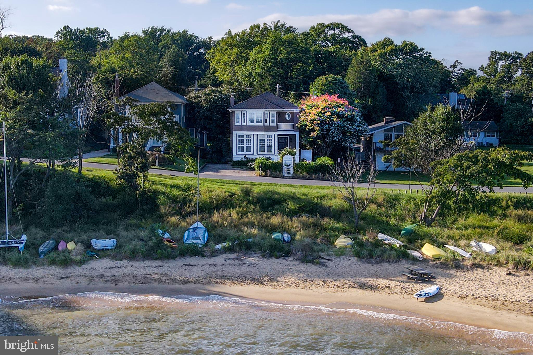 This magnificent home in the heart of the sought-after community of Bay Ridge offers the breathtaking Chesapeake Bay views you have been looking for. This coastal infused home is non-riparian waterfront with direct beach access just steps from your front door. This classic 1930’s home was re-constructed, expanded and renovated to offer a modern floor plan yet still has the original charm throughout.  Features of the main level include a living room with wood burning fireplace, window-wrapped sunroom, gourmet kitchen, separate dining room, cozy sunken family room with custom built-ins & wood burning fireplace, and a powder room.  The top floor offers a fabulous waterfront master bedroom with luxurious bath, large walk in closet, and a balcony overlooking the bay.  This level is completed with three additional bedrooms, a full bathroom, and full laundry room.  The unfinished lower level is perfect for a recreation or play area.   A beautifully landscaped front yard offers bayside seating, a stone paver driveway for three cars and an outdoor shower.  The large rear yard offers a flagstone patio, garden, and endless possibilities to enjoy or entertain.  A storage shed and additional parking for multiple cars can be found at the rear of the property.  The Bay Ridge Community offers a private pool & club house with panoramic Chesapeake Bay views, marina, boat ramp, beach, and playground.  With easy access to Historic Downtown Annapolis & Washington, DC, this Bay Ridge beauty is not to be missed!