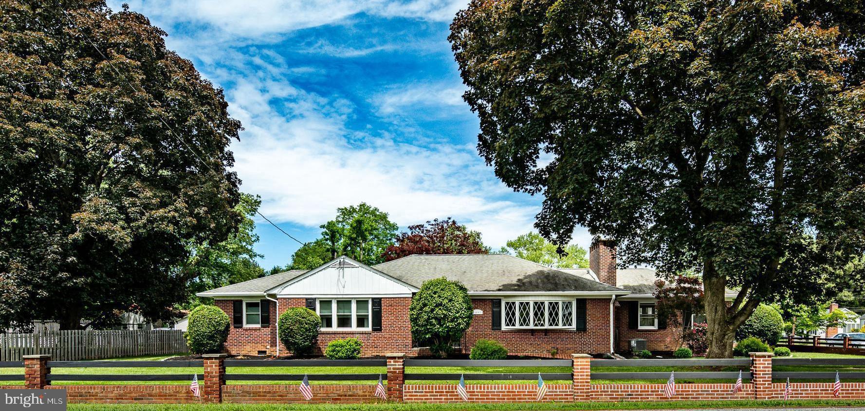 Welcome to this extraordinary one-of-a-kind custom red brick extended ranch, offering luxurious single-floor living, timeless elegance, & impeccable craftsmanship throughout. Perfectly blending sophistication & comfort, this meticulously maintained 4-bedroom, 3.5-bath residence is overflowing with upscale amenities, architectural charm, & exceptional Pride of Ownership. (4th  bd/office) Step into the grand welcoming foyer that opens into an expansive sun-drenched living room featuring gleaming refinished hardwood floors, a dramatic oversized picture window & stunning detailed fireplace that creates a warm & inviting ambiance. The elegant oversized formal dining room, adorned with classic chair rail detailing, provides the perfect setting for unforgettable dinners & entertaining guests in style. Spectacular gourmet chef’s kitchen is truly a showstopper, boasting luxurious granite countertops, premium Saint Charles custom cabinetry, a Viking 42-inch 6-burner cooktop, stainless steel appliances, oversized pantry, imported Turkish tile backsplash, heated porcelain flooring, & designer fixtures throughout. Gorgeous refinished hardwood flooring flows seamlessly throughout the home and has been specially sealed to maintain its brilliance and resist yellowing for years to come. A breathtaking custom cherry wood office/den serves as a remarkable retreat featuring rich built-in millwork, an impressive floor-to-ceiling stone fireplace with wood-burning stove, cedar closet, convenient half bath, and a magnificent custom cherry executive desk that remains with the home. This versatile and sophisticated space also offers the potential for a fourth bedroom or private guest suite. Retreat to the luxurious primary suite, a true private sanctuary featuring an expansive dressing room with vanity area, elegant marble flooring, oversized custom walk-in closet, spa-inspired walk-in shower with hand-selected imported tile, heated floors, &  exquisite designer finishes. Two additional generously sized bedrooms & a beautifully updated hall bath with marble flooring, upscale international tile selections, and elegant fixtures complete the main level. The stunning sunroom is flooded with natural light through oversized windows showcasing peaceful panoramic views. Featuring beautiful tiled flooring and charming French doors leading into the home, this serene space is perfect for morning coffee, reading, relaxing, or entertaining year-round. The impressive approximately 2,000-square-foot finished lower level dramatically expands the living space and offers endless possibilities. This exceptional area includes a massive gathering room anchored by a third grand fireplace, spacious great room, expansive custom bar area, full bath, private exterior entrance, enormous tiled laundry room with extensive storage, and two oversized utility/storage rooms—making it ideal for an in-law suite, guest quarters, recreation area, or multi-generational living. Outside, discover your own private backyard oasis surrounded by lush landscaping and extensive custom hardscaping. Enjoy three newly paved patios, beautifully designed walkways, updated exterior lighting, new fencing, and an 8x16 storage shed—all creating an incredibly private & tranquil setting perfect for outdoor entertaining & relaxation. The immaculate oversized two-car garage features new flooring, electric garage door, plumbing access, & both front & rear entry access. An expansive driveway provides parking for 8+ vehicles with ease. Additional premium upgrades include newer windows, recessed lighting with built-in speakers and dimmers, updated plumbing and electrical systems, attractive ceiling fans, heated flooring, & recently serviced HVAC & central air systems (April 2026). Ideally situated near the Delaware border for convenient tax-free shopping & just minutes from I-95, Rts 495, 322, 1, & 202, PHL Airport, Center City Philadelphia, premier dining & shopping. This is truly a MUST SEE INSIDE HOME!