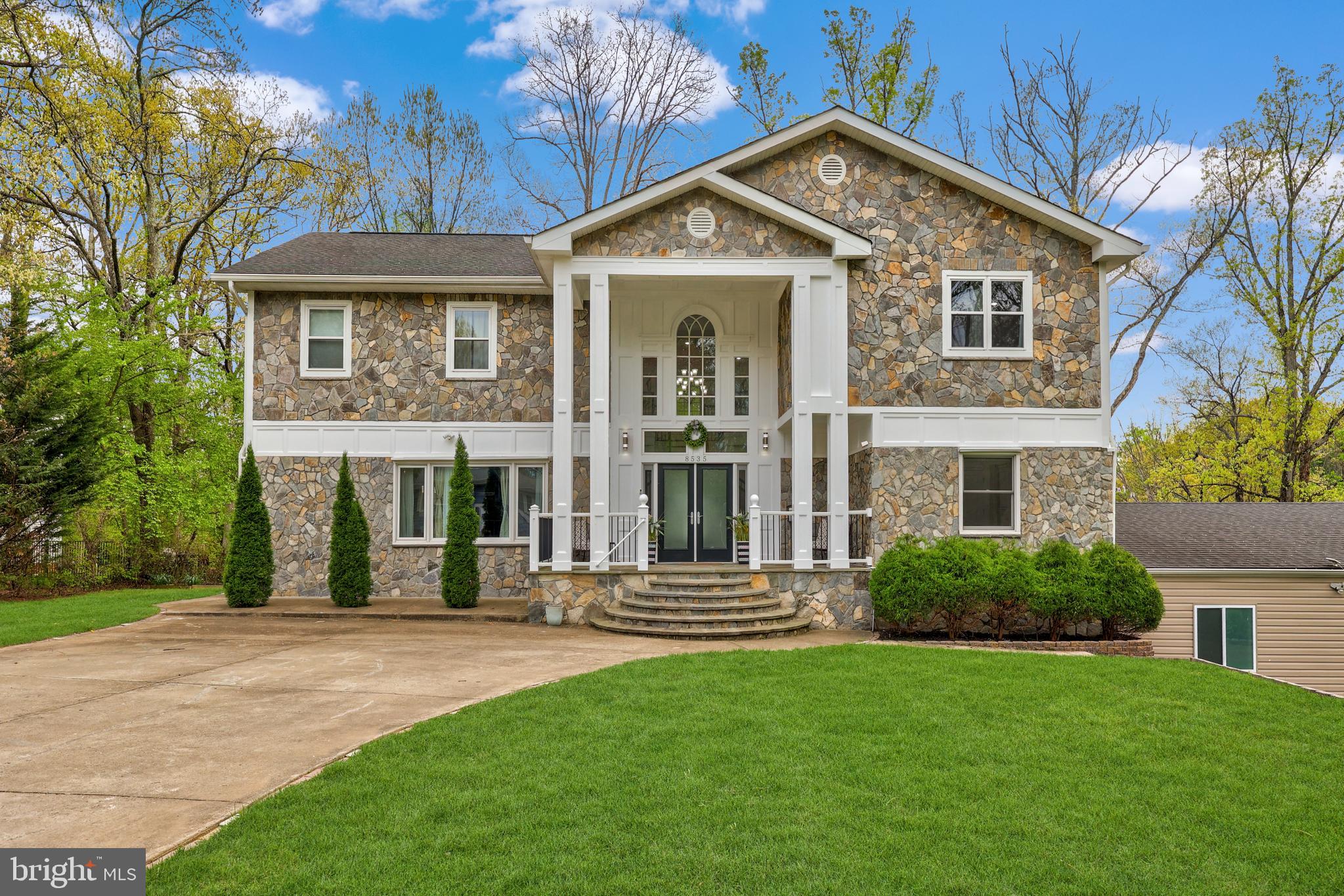 Welcome to this beautifully updated colonial offering over 5,000 square feet of living space in the highly sought-after Wakefield Forest neighborhood and the Wakefield Forest Elementary, Frost Middle, and Woodson High School pyramid. Situated on a spacious half-acre corner lot, this impressive home features two driveways and a three-car garage, providing both convenience and exceptional curb appeal.

Completely reimagined from top to bottom in 2015, this expansive home features a full upper-level addition and a stunning exterior transformation, offering the perfect blend of scale and thoughtful design. Major systems—including plumbing, HVAC, electrical, full home recessed lighting, and roof—were all updated as part of the renovation, providing both modern comfort and peace of mind. From the moment you step inside, you’re greeted by a dramatic two-story foyer, where a grand double staircase creates a striking and unforgettable.

The main level showcases beautiful Brazilian cherry hardwood flooring throughout and an abundance of natural light. Designed with both everyday living and entertaining in mind, the open floor plan flows effortlessly between the living spaces. The spacious dining room sits adjacent to the gourmet kitchen, which features a large island, stainless steel appliances, granite countertops with matching backsplash, and warm wood cabinetry. Architectural details such as crown molding, arched columns, and recessed lighting add character and elegance throughout the main level.

Just off the main living area, double french doors lead to an oversized Trex deck overlooking peaceful greenery—an ideal setting for relaxing evenings or hosting gatherings with family and friends. This level also includes a powder room and a main-level bedroom that offers flexibility as a guest room or private home office.

Upstairs, the Brazilian cherry hardwood flooring continues throughout the upper level. The spacious primary suite serves as a true retreat, featuring two walk-in closets and a spa-like en-suite bathroom with a double vanity topped with quartz countertops, a jetted soaking tub, and a separate standing shower. Three additional bedrooms complete the upper level, including one with its own en-suite bathroom and two that share a well-appointed hall bathroom.

The walk-out lower level provides even more living space with a large recreation room perfect for a game room, media room, or additional entertaining space. A separate room off the garage offers an excellent opportunity for a home gym, while the lower level also includes a full bathroom, a bonus room, and a den that can be reimagined to suit your needs, whether as a larger laundry room, additional living space, or hobby area.

Conveniently located just off Little River Turnpike, this home offers easy access to I-495 and is only minutes from Old Town Fairfax, Pickett Shopping Center, Fair City Mall, INOVA Fairfax Hospital, Mosaic District, and Tysons Corner. With its expansive living space, prime location, and highly desirable school pyramid, this home presents an exceptional opportunity.