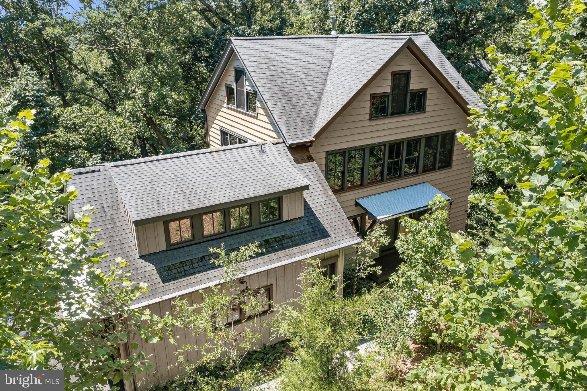 3800 sf 4br/3ba high-end craftsman home with 2-car garage and rooftop deck in the tree canopy, built new in 2019.  Located on Severn River’s most gorgeous Chase Creek, with deep water community dock and kayak rack for your boat(s). Hundred-year-old neighborhood is surrounded by water at the end of a half mile of forest and horse farms, yet it is just 8 min from the Naval Academy, 10 min from downtown Annapolis, and 25 minutes to BWI Airport.  It’s also on the Baltimore to Annapolis Rail-Trail for easy commuting into Annapolis.  Retreat-like setting with 360 tree and tree canopy views and seasonal water views from 65 top-of-the-line Marvin windows, with permanent clear views between the house and the tidal Chesapeake Bay tributaries below.  Low maintenance lot/yard is a highly diverse mix of native species trees and shrubs that will grow more gorgeous as they continue to mature. Daylight basement family room with separate entrance that easily can be used as a studio apartment to accommodate multi-generational family arrangement, or it can be under Maryland’s new ADU laws be easily (with a building permit) converted into a separate ADU.
This house is extraordinarily crafted by the builder who lived here for five years. All hardwood and natural stone floors. Oak and steel spiral stairs, stair shelf walls, Amish-crafted cherry interior doors—all expertly trimmed with matching wood.  Custom cabinetry from local cherry trees, live edge walnut bar and other walnut accents, Douglas fir posts and beams everywhere. Bathroom wainscot and all walls of the garage have been paneled with gorgeous salvage lumber and brick from demolished homes in Baltimore. All 9 main rooms have their own Mitsubishi ductless mini-split air conditioning and heating system, with remote control.  Five exterior French doors are highest quality Marvin.  All exterior siding and porch structural wood is non-rotting and termite-proof Port Orford cedar (Pacific cypress) cut to specified size from Oregon sawmill. This siding is placed over an air gap outside of a waterproof inner shell for exceptional insulation and structural longevity. Wired for high speed internet suitable for telework.