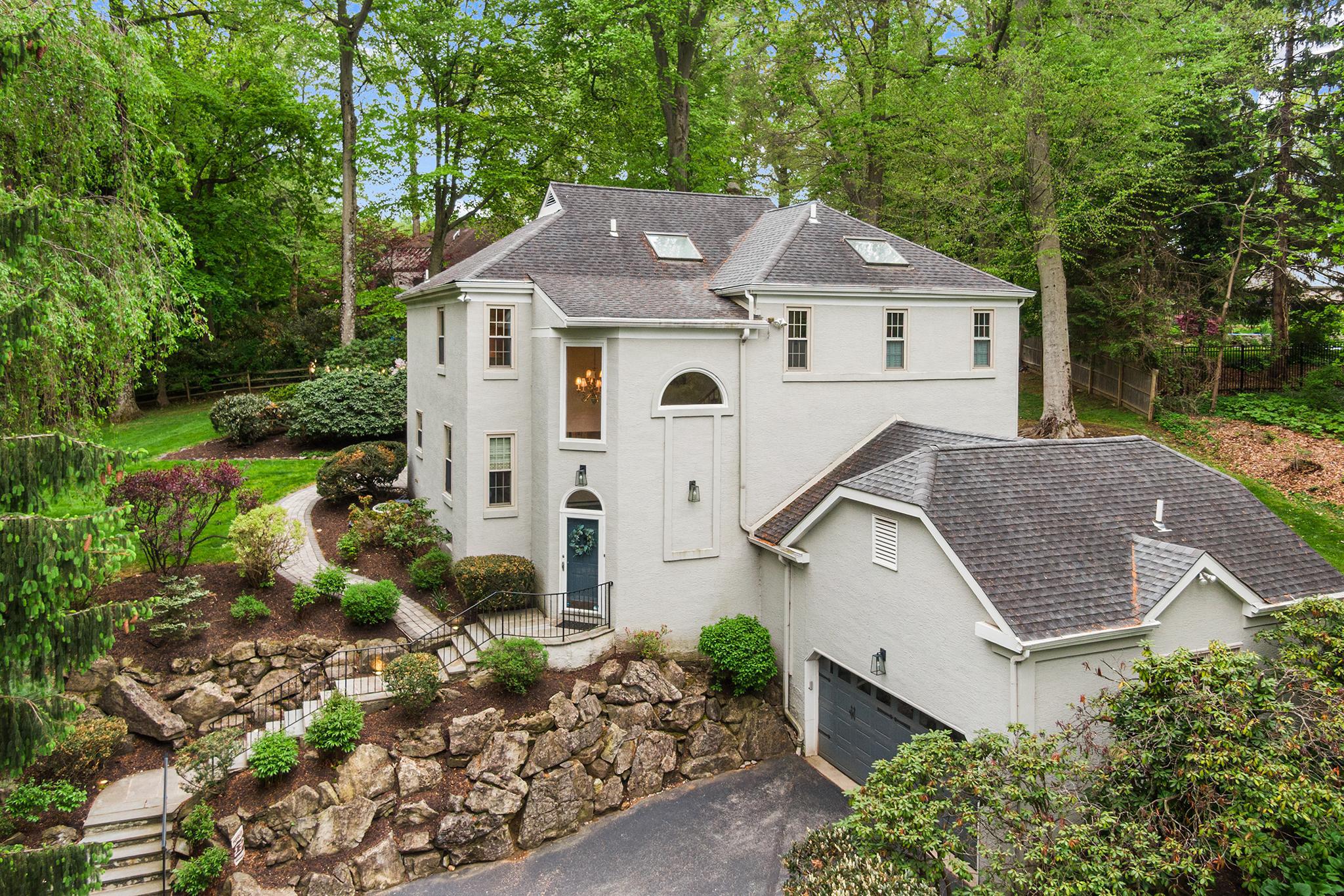 Welcome to 2114 Greenbrier, a stunning 4-bedroom, 2.5-bathroom sanctuary nestled in the highly coveted Villanova community and the acclaimed Lower Merion School District. Tucked away on a peaceful 0.68-acre cul-de-sac lot, this home offers over 3,500 square feet of sophisticated yet inviting living space. It lives like a completely secluded retreat, yet you are just minutes from premium shopping, dining, commuter rails, and top-tier schools, not to mention a short stroll to The Inn at Villanova University, scenic walking trails, and a local dog park. A charming stone-accented stairway welcomes you to a dramatic two-story foyer, where brilliant natural light highlights gleaming hardwood floors and exquisite wood trim. The heart of this open-concept home is the stunningly updated kitchen, showcasing custom cabinetry, rich granite countertops, a sleek glass subway tile backsplash, and a dedicated beverage bar. An oversized center island with chic pendant lighting creates the ultimate hub for daily life and holiday entertaining alike. This culinary space flows effortlessly into a sun-drenched dining area framed by oversized windows and a cozy family room anchored by a warm fireplace—the perfect layout for both intimate dinners and lively gatherings. When you are ready to unwind, sliding glass doors invite you into an expansive enclosed sunroom, perfectly blurring the lines between indoor comfort and the picturesque landscape outside. From here, venture out onto a charming stone walkway that winds through your private garden and lush, sprawling backyard. This incredible outdoor oasis is tailor-made for summer barbecues, relaxing evenings by the firepit, or quiet nights spent stargazing. Back inside, the main floor is seamlessly completed by a private home office, a convenient laundry room, and a beautiful half bath. Upstairs, the luxurious Primary Suite awaits as your personal getaway. It features sweeping backyard views, two custom walk-in closets hidden behind clever pocket doors, and a spa-inspired ensuite bath complete with dual sinks, a large walk-in shower, and a skylight. Three additional generously-sized bedrooms provide plenty of comfort and share a bright, skylit full bathroom in the hall. Downstairs, the finished lower-level delivers exceptional versatile bonus space—ideal for a home theater, gym, playroom, or secluded retreat—with direct access to the two-car garage and ample storage. Offering sophisticated style, a flawless modern floor plan, and unmatched Main Line convenience, this Villanova gem is truly special. Book your showing!