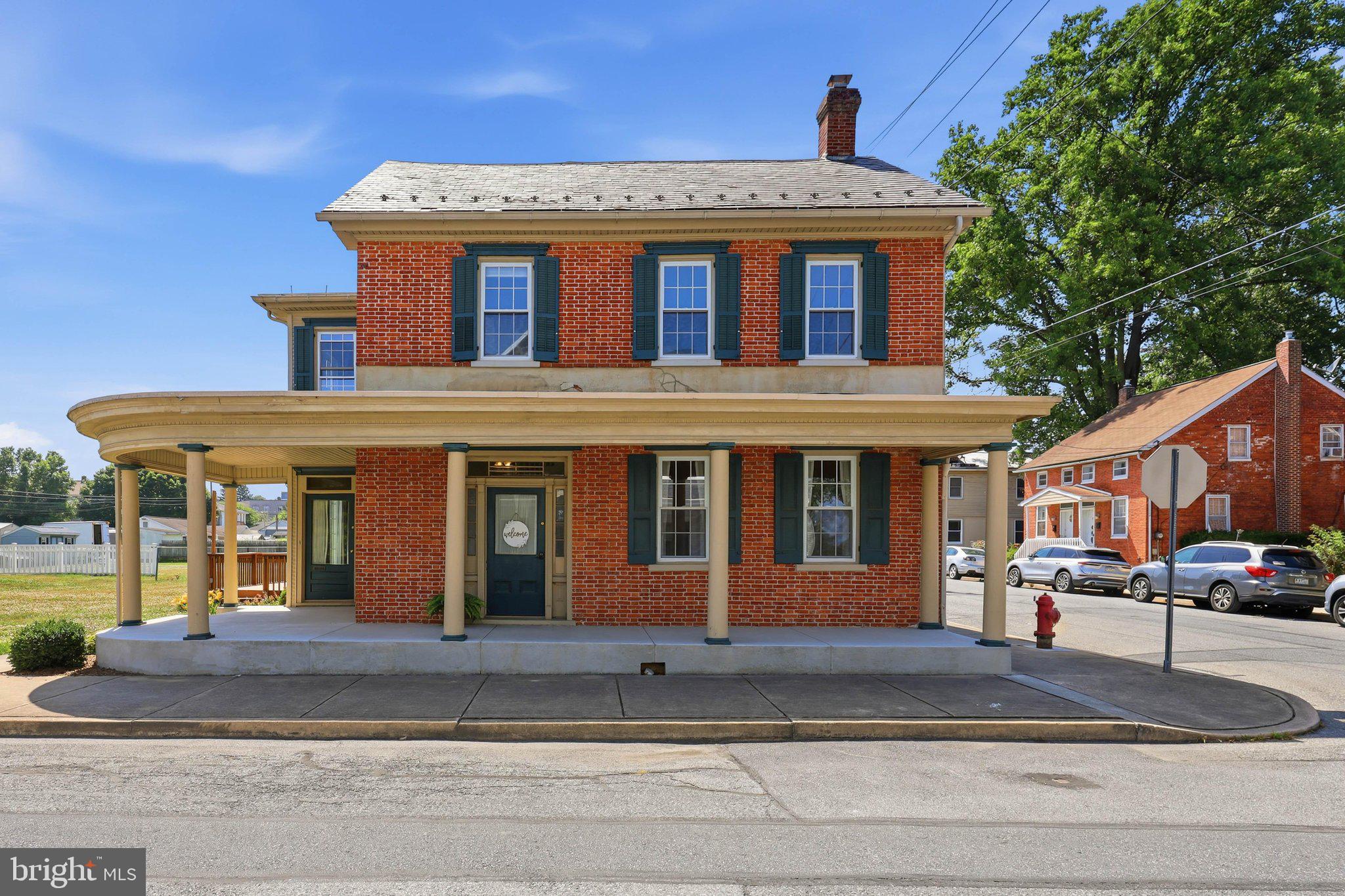 Step into the timeless charm of 222 Mount Joy Street, where the character of a beautifully preserved 1880 brick home meets the comfort and convenience of thoughtful modern updates. From its stunning brick façade to its welcoming wrap-around porch, this is a home that invites you to slow down, relax, and savor every season. Begin your mornings with a cup of coffee on the wrap-around front porch, enjoy quiet evenings on the side porch, or host friends on the back deck overlooking the backyard. With a detached two-car garage and off-street parking, you will enjoy both charm and practicality from the moment you arrive. Brand-new windows throughout the home enhance both its beauty and energy efficiency.
Inside, the spacious living room is warm and inviting, anchored by a classic brick wood-burning fireplace, complete with a mantel and hearth. Large windows bathe the room in natural light, while lovely luxury plank flooring flows throughout the entire first floor, creating a seamless and homey atmosphere. A discreetly located full bathroom adds everyday convenience for you and your guests.
The heart of the home is the generously sized kitchen, designed for both everyday living and entertaining. You will find an abundance of cabinetry, acres of countertop space, and a large pantry to keep everything organized. Unique architectural details—including exposed wood beams, paneled doors, and oversized baseboards—add warmth and personality throughout the space. Whether you envision a cozy breakfast table or a spacious center island, there is plenty of room to make it your own.
Just beyond, the dining room offers an ideal gathering space with large windows that fill the room with sunshine and direct access to the wrap-around porch. A wide entryway leads into an expansive family room where soaring windows surround the space and pour in natural light, creating the perfect setting for  Upstairs, the spacious primary suite provides a peaceful retreat with large windows and a private ensuite bath, featuring a granite-topped vanity, tub-and-shower combination, and elegant wainscoting. Three additional bedrooms are bright, spacious, and comfortable, each offering large windows and impressively sized closets.
One of the home's most versatile spaces is the dedicated laundry room, complete with a comfortable seating area. Whether you need a home office, craft room, reading nook, or library, this flexible room easily adapts to your lifestyle. A second full bathroom completes the upper level.
The third floor offers even more possibilities with a fifth bedroom featuring plush carpeting, a large closet, and an expansive storage area—perfect for guests, a private workspace, or a quiet retreat.
Filled with timeless character, generous living spaces, thoughtful updates, and inviting places to gather both inside and out, 222 Mount Joy Street has been lived in, cared for, and loved. And now it is waiting for more memories to be made.
