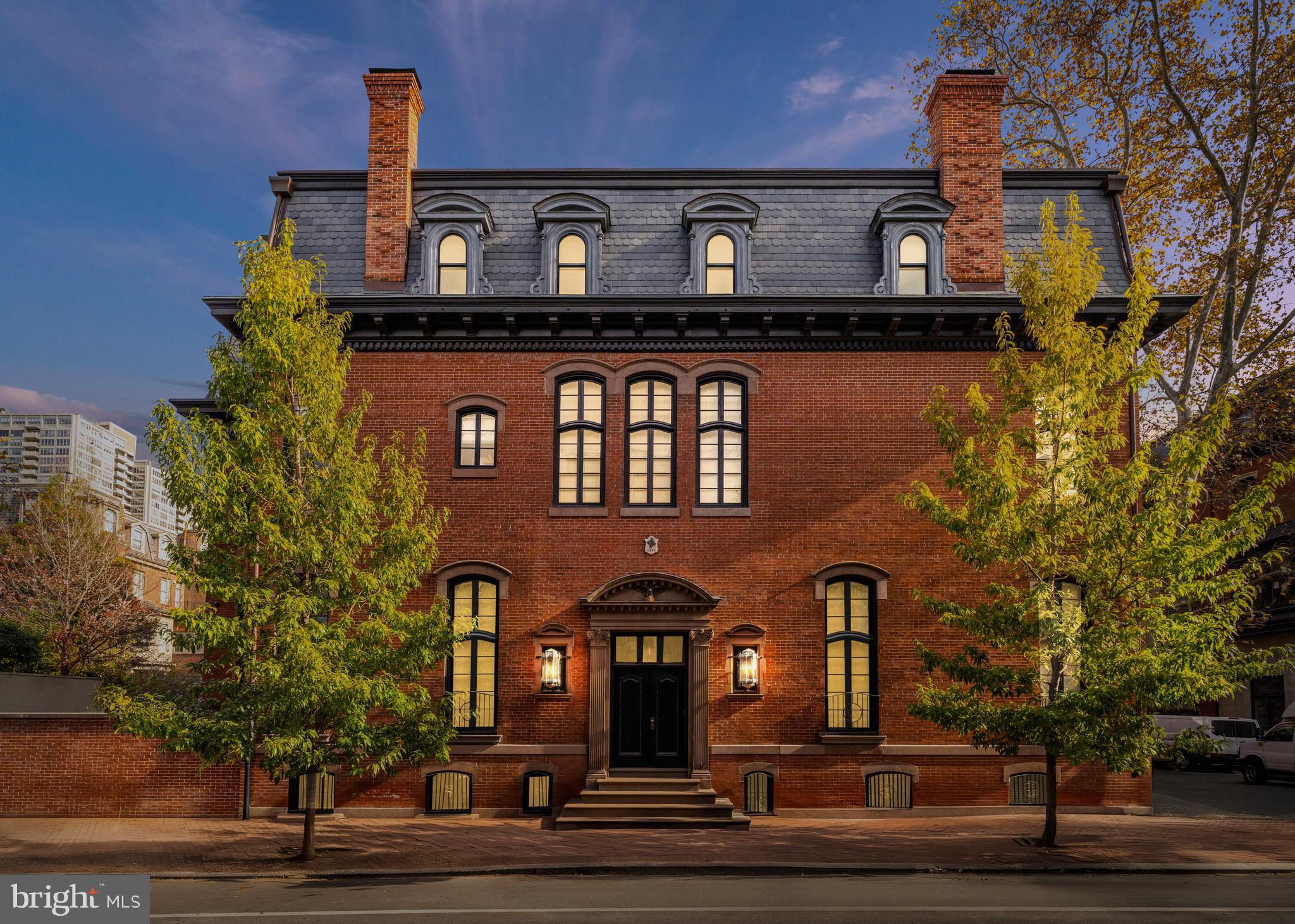 Old-world grandeur and modern European inspired luxury await in this meticulously renovated historic corner rowhouse featuring magazine-worthy designer interiors, an elevator and private outdoor space/parking on the most coveted block in Philadelphia, just inches from Rittenhouse and Fitler Squares.
Featured on the Philadelphia Register of Historic Places, this 1863 residence received a painstakingly thorough restoration from a collaboration between Philadelphia based STUDIO EDO and S.R. Gambrel from New York, that shows utter reverence for the home’s historic origins while adding bespoke upscale finishes and contemporary conveniences. Inside the 7,500-square-foot showplace, you’ll find an ideal layout for comfortable living and lavish entertaining alike. Ceilings soar up to almost 14 feet tall over exquisite millwork, custom finishes, hardwood and stone flooring, and oversized windows on three exposures, delivering unprecedented natural light throughout. 
The 5 feet raised first floor, gives the lightwells a traditional window height. The lower ground level (cellar level), with ten feet ceilings, rough coat plaster walls and Belgian black heated stone floors making an inviting spot for everyday and casual gatherings. From the family room the view of the exceptional and spacious gourmet kitchen impresses with swaths of rich stone and custom lit cabinetry in limed oak. The state-of-the-art appliances include a vented La Cornue double oven range with a pot filler, two Sub-Zero refrigerators with freezers, two dishwashers and an ice maker. The massive center island adds a prep sink, seating and more storage, flanked by an open pantry with more counter space, a row of triple drawers and open lit shelving. A vitrine style butler’s pantry brings even more room for display and storage along with an independent coffee station and two large-capacity wine refrigerators. A powder room, mudroom and outdoor access with a spacious storage bunker and a wood, charcoal and gas barbecue designed and built in Argentina complete the lower level. 
The home’s second level is dedicated to the tranquil owner’s retreat, featuring a sprawling king-size 13.5 feet high bedroom suite, with linen covered wall panels perfect for sound proofing, incorporated television. motorized blackout drapery, double exposures and a marble wood burning/gas fireplace. The Savile Row inspired limed oak dressing room with bespoke wooden hangers creates a handsome walk-in closet that attends to all wardrobe needs. The en suite spa bathroom boasts a double vanity, private water closet and rain-steam shower, all trimmed with fine stone and stained silver oak. A regal library offers floor-to-ceiling hand-lacquered paneling, inked glass panel insets and retrofitted bookcases and a hidden television.  A concealed home office provides a private space for work with a gorgeous view of the surrounding homes and the Philadelphia skyline. The wood burning/gas fireplace framed in antique bronze and malachite panels as well as the cozy designer details invites you to curl up to enjoy your favorite novel or movie. The landing of the top floor is crowned by a Mayfair, London style skylight to flood the space with natural light and wash the Venetian plaster finished walls. 
On the skylit top floor, two secondary suits and a large den, also ensuite, all include glamourous designer finishes and ensuite spa bathrooms, while rows of additional closets and a laundry room add convenience. Outside, a stunning brick façade with stone details, a mansard roof and dormer windows deliver  curb appeal while the fenced courtyard is perfect for al fresco entertaining or off-street parking for one vehicle. From this outstanding Rittenhouse location, you're surrounded by the neighborhood’s centerpiece park and renowned local dining, with Philadelphia's best historic site, museums and amenities all within easy reach.