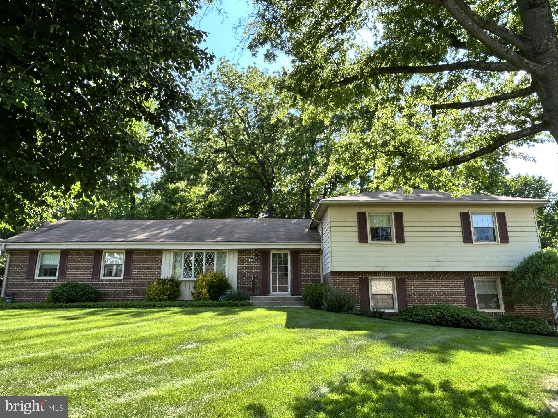 Large four-level split home in Enterprise Estates in Bowie! Lovely and generous front yard and private wooded area directly behind property/back yard. Brick/vinyl home features TWO large living rooms, a wood-burning fireplace, a dining room and your kitchen on walk-in level. Two-car garage opens at back of home and the driveway can fit six more vehicles; enter mudroom area where a large pantry/wine racks and kitchen greet you! Two sinks in kitchen, white appliances and plenty of room for an eat-in area. Hardwood floors in dining room and under all carpeted areas, just waiting for your special touches! This Delaware model home features a larger primary bedroom with three closets and a larger tub/shower in the primary bathroom. Glass sunroom off the lower-level rec room that boasts a second wood-burning fireplace. Large workbench on rec room level; fourth bedroom and half bath off hallway; lower basement level is unfinished and houses your utilities, a full-house Kohler built-in generator, Maytag washer and dryer and a stand-alone chest freezer! Please enter home from side garage door.