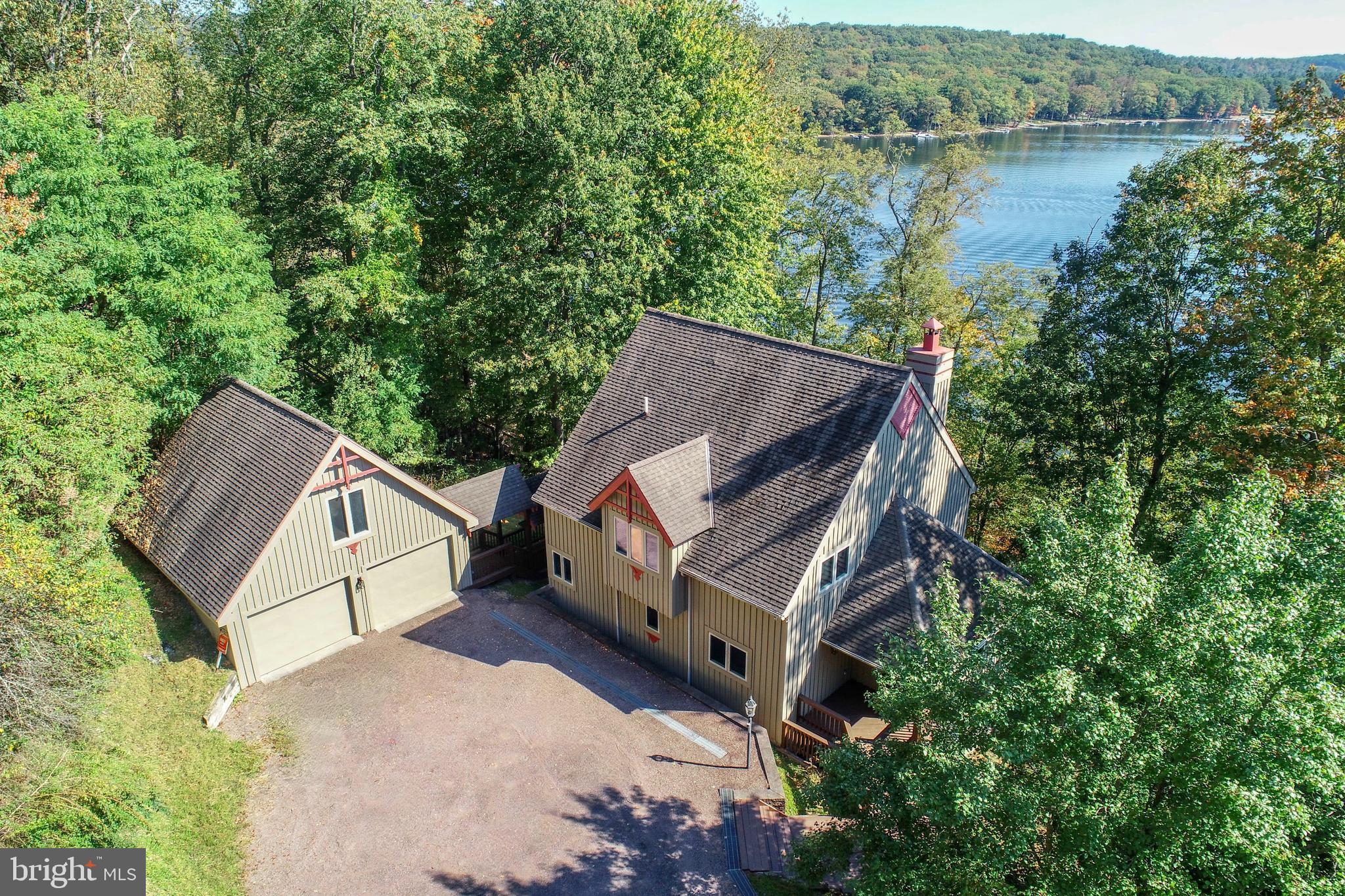 Architecturally unique, private and spacious lakefront home with a perfect central location!

Step into a home that blends striking architectural design with the best of lake living. The living room showcases a dramatic wall of glass and a floor-to-ceiling stone fireplace, while a large glass-walled rec room on the lower level offers another light-filled space to relax or entertain. This 5-bedroom, 3-bath residence includes a spacious private primary suite with its own balcony, plus a main level bedroom, and three lower-level bedrooms, two overlooking the lake! Multiple decks, and a hot tub with a peaceful water view backdrop.

Enjoy the rare combination of being centrally located yet tucked away in a private setting, giving you both convenience and privacy. With a 2-car garage, private stairs leading to the boat slip, and the advantage of being an affordable lakefront opportunity. This property is perfectly designed for enjoying all Deep Creek Lake has to offer!

Highlights:  Architecturally distinctive design-Wall of glass & floor to ceiling stone fireplace in living room-Rec room with a wall of glass-5 Bedrooms/3 full baths, including 2 lower level bedrooms with lake views-Private spacious primary suite with a private balcony-170' of lakefront for privacy and a boat slip-Hot tub overlooking the water-Multiple decks & outdoor entertaining areas-2 car garage-Affordable lakefront in a private yet central location.  A true retreat with the perfect balance of style, privacy, and value!