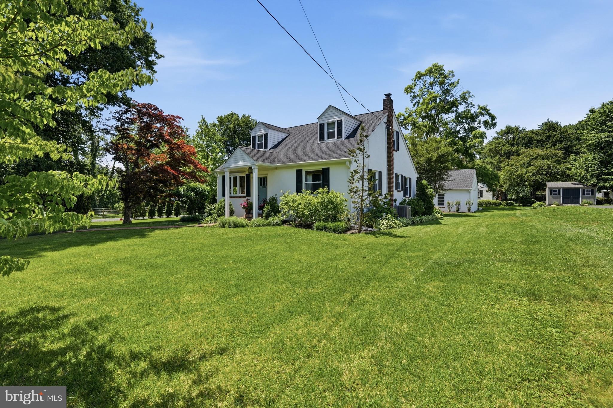 Picture-perfect Cape Cod-style home with extensive updates located in historic Langhorne Manor. Set on a half-acre lot showcasing beautifully manicured gardens, mature trees, and outstanding curb appeal, this move-in ready home offers the perfect combination of timeless character, modern updates, and everyday comfort. Enjoy the convenience of being just a short walk to the train station while experiencing the charm of one of Langhorne’s most sought-after neighborhoods. Thoughtfully designed and filled with natural light, this home lives larger than its footprint. Inside, you will find inviting living spaces featuring hardwood floors and tasteful fixtures throughout. The spacious family room includes plenty of windows that brighten the space and create a welcoming atmosphere. The family room opens to a custom kitchen that blends style and functionality with a full Bosch appliance suite, including a new refrigerator (2025), smart storage solutions, quality finishes, and a large center island that creates the perfect gathering space. In addition to gas cooking, the home offers efficient natural gas heat and hot water. The main-level primary bedroom features custom built-in cabinets for exceptional storage and organization. A thoughtfully remodeled full bath showcases an attractive vanity, updated fixtures, and a beautifully tiled floor and tub/shower surround. An additional bedroom completes the main level, offering flexibility for guests or home office. Upstairs are two generously sized bedrooms with ample storage space and a beautiful full bath that has been thoughtfully remodeled with tile flooring, vanity, and seamless glass stall shower. Step outside to a professionally designed outdoor living space with a large patio, accent walls, and extensive landscaping, creating an ideal setting for entertaining, outdoor dining, or simply enjoying the peaceful surroundings. The oversized, detached two-car garage provides additional space for storage, a workshop, or other versatile uses. Both house and garage have full gutter guards. A rare opportunity to own a beautifully maintained home in the heart of historic Langhorne Manor.
