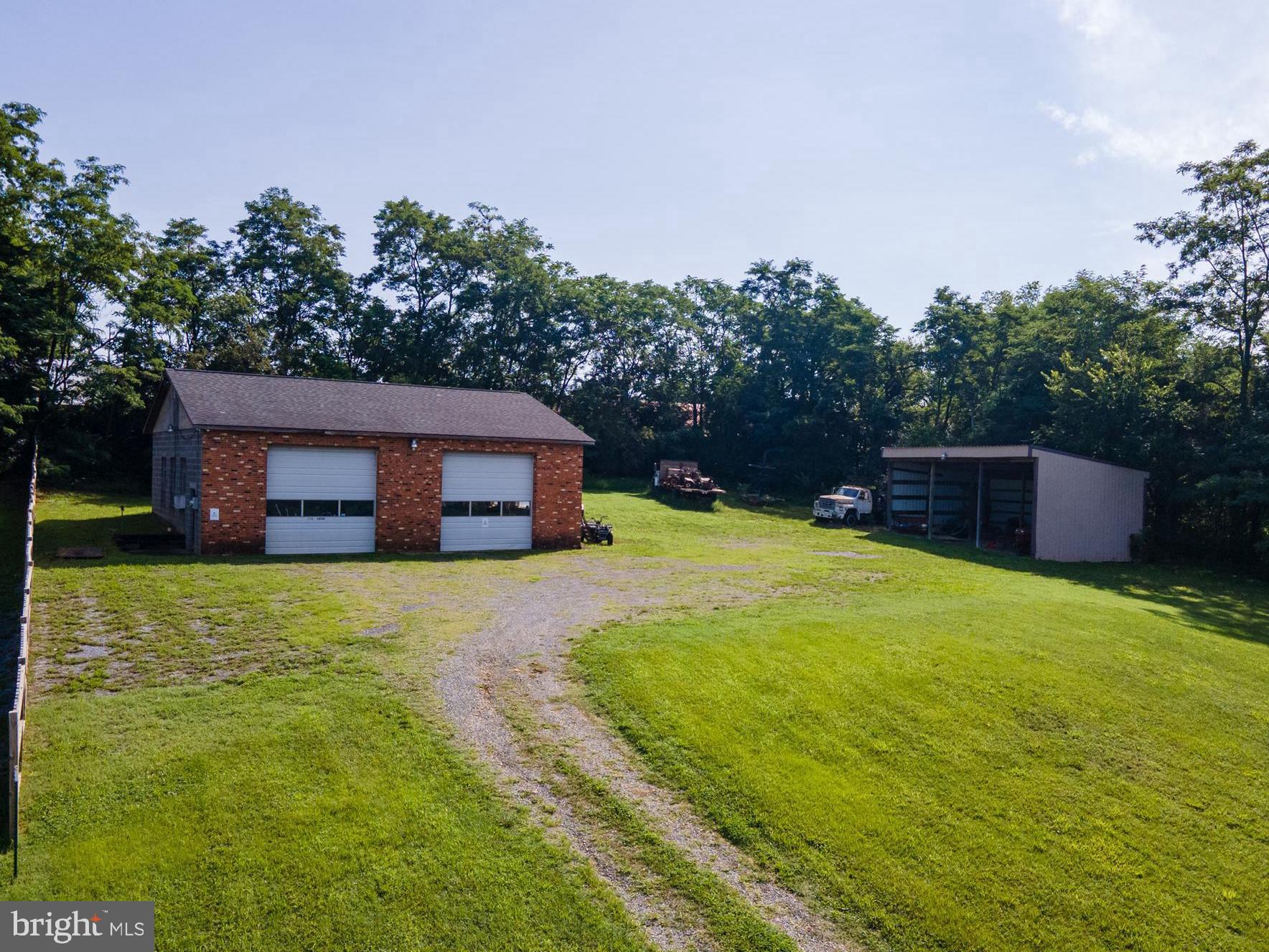 Bring your vision to life on this versatile 1.43-acre property featuring two impressive outbuildings. The 40' x 45' block and brick garage offers 1,800 square feet of space with 14-foot ceilings, installed electric, automatic overhead doors, a poured concrete floor, and loft storage accessible by stairs. An oversized three-bay pole building provides additional covered space for equipment or large vehicles. Whether you're dreaming of building a home, creating the ultimate workshop, or just need additional outdoor storage, this property offers a blank canvas to make it your own. Public water is available at the road, but a private septic system would need to be installed to accommodate any bathroom facilities.