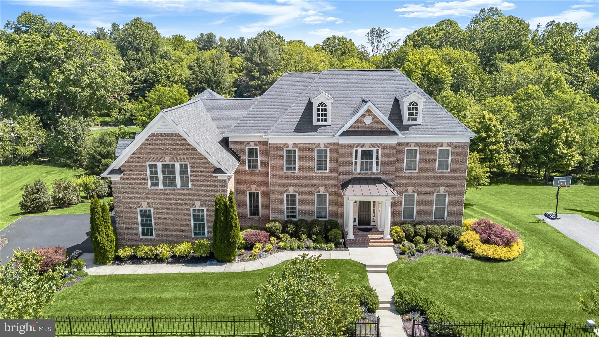 Welcome home to 7738 Elmwood Road - a magnificent Maple Lawn Estate Home prominently positioned on an expansive lot on one of the most coveted streets in the Midtown-West District. Crafted by renowned luxury builder Mitchell & Best, this Eagle's Nest model boasts 6 bedrooms, 5.5 bathrooms, and more than 9,000 square feet of luxury living space - every inch of which has been meticulously maintained by its owners. The nearly half-acre lot backing to mature trees is enhanced by a sizable TREX deck, spacious paver patio with fire pit, and a three-car garage. Main level interior highlights include a grand two-story foyer and hardwood flooring throughout. The formal living room offers recessed lighting, three-piece crown molding, and four windows for abundant natural light. Adjacent, the formal dining room features extensive moldings, a large picture window overlooking the backyard, and French doors leading to the kitchen. The kitchen is equipped with a full array of top-of-the-line appliances, wine fridge, and oversized granite center island. A sunroom off the kitchen provides an ideal eat-in area with French door access to the TREX deck. The family room offers a double-tray ceiling, a wall of windows with views of the private backyard, and a gas fireplace with a stone surround. The main level is completed by a private office with French doors, a well-organized mudroom with a “welcome center,” a large coat closet, a laundry room, and a half bath.

The upper level presents an exquisite retreat with a second office featuring elegant French doors. The primary bedroom is a sanctuary complete with a sitting room, private balcony, two spacious walk-in closets, and a cozy gas fireplace. Adjacent is the spa-like primary bathroom with two large vanities, a luxurious soaking tub, and an expansive shower stall. Also on this level -  a full hallway bathroom, two secondary bedrooms sharing a well-appointed bathroom, and a guest bedroom with its own en-suite bathroom, ensuring privacy and convenience for all residents and visitors. Immediately noticeable in the walk-out lower level is the amazing amount of daylight from so many windows. This level will be your entertainment hub with a custom wet bar, gas fireplace, and two more bedrooms which could serve as a gym or yoga studio. Also enjoy a full bathroom with frameless shower door, an unfinished storage area, and more French doors leading to the patio outside. Maple Lawn residents enjoy unparalleled amenities including a pool, clubhouse, fitness center, sports courts, walking trails, dog park, playgrounds, and convenient access to all major Baltimore/DC commuter routes. 7738 Elmwood Road is a rare offering and property of distinction in Howard County’s most prestigious community. Don’t let it slip away.