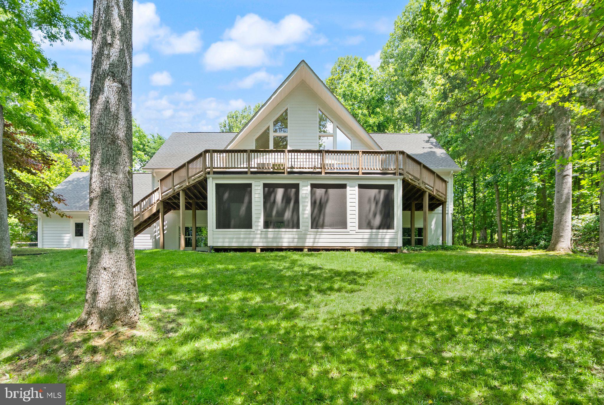 Welcome to 38620 Lime Kiln Road, a 4.83-acre Leesburg retreat with Goose Creek frontage and no HOA. Surrounded by mature trees and a beautifully maintained natural setting, this property offers the peaceful feel of country living while remaining just minutes from historic downtown Leesburg and major commuter routes.

The home features an updated kitchen with refinished hardwood floors, quartz countertops, and gourmet appliances, opening to a dramatic two-story living room filled with natural light. A spacious Trex deck provides the perfect place to entertain or enjoy views of the property.

The main level includes the owner’s suite with deck access, a second bedroom or office, a full bath, a large laundry and mudroom, and a versatile bonus room above the garage with a separate entrance. Upstairs are two additional bedrooms, a full bath, and a reading or game nook. The finished lower level offers two oversized bedrooms, a large recreation room, a full bath, a screened porch, and abundant storage.

Notable features include Hardie plank siding, fresh exterior paint, a whole-house Kohler generator, two EV chargers, two wells, water treatment equipment, an Aprilaire whole-home dehumidifier, a Pentair constant-pressure well system, a Bradford White water heater, and a Carrier Infinity HVAC system.

A private driveway across Lime Kiln Road leads to a peaceful waterfront area along Goose Creek, complete with seating overlooking the water. With nearly five acres, Goose Creek frontage, extensive system upgrades, and easy access to Leesburg, Middleburg, wineries, dining, parks, and trails, this property offers a rare opportunity to enjoy the best of Loudoun County living.