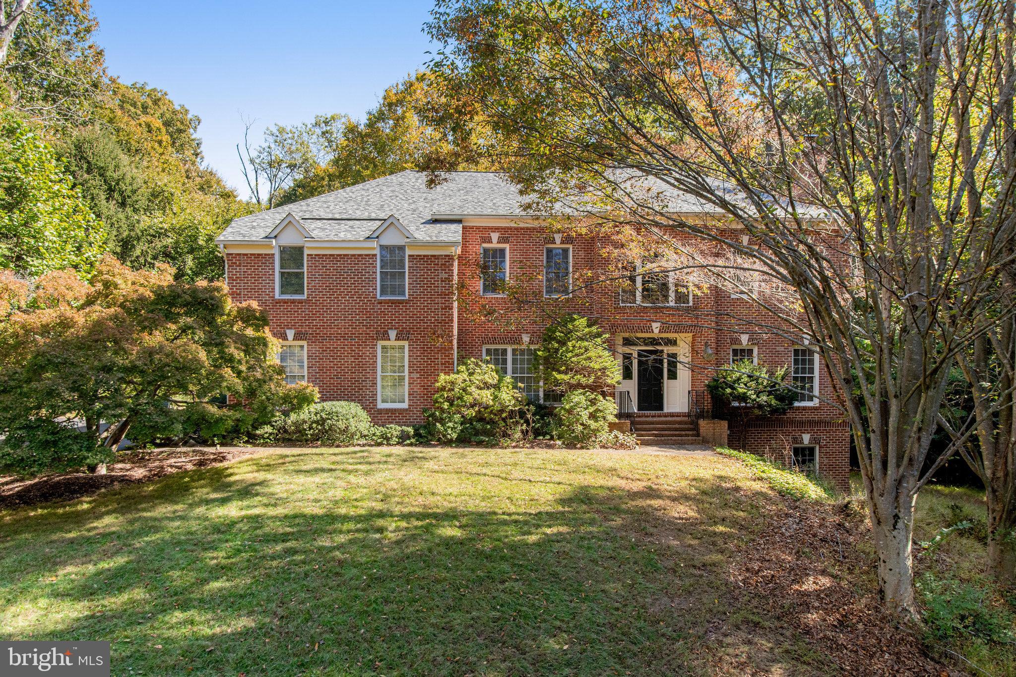 On a quiet no-through street don’t miss this brick colonial sited on a beautiful and secluded 2-acre property.  The neighborhood trail leads to the Potomac River and Riverbend Park and is less than a mile to Riverbend Country Club. The residence offers 4 bedrooms plus 3 full baths and 2 half baths situated in a beautiful private yard with mature trees.  There is great flow and transitions between spaces on over 4800 sq ft of living space.  Notable highlights on the main level include the large family room with dramatic 12-foot ceiling and a wall of windows with views of the woodland scenery, and 2nd staircase which is open to the eat-in kitchen with island and gas cooktop.  The upper level offers the perfect owner’s suite with a sitting room, gas fireplace, dressing room, walk-in closets and spacious bathroom. 
The 2nd bedroom is ensuite, bedrooms 3 & 4 share a buddy bathroom, and all three bedrooms include carpeting and large closets.  The walk-out lower level provides tall ceilings, full sized windows and bathroom rough-in, a great opportunity to create the guest suite and rec room of your dreams.   Bounded by nature the exterior features a multi-level deck and boardwalk leading into the woodlands.
