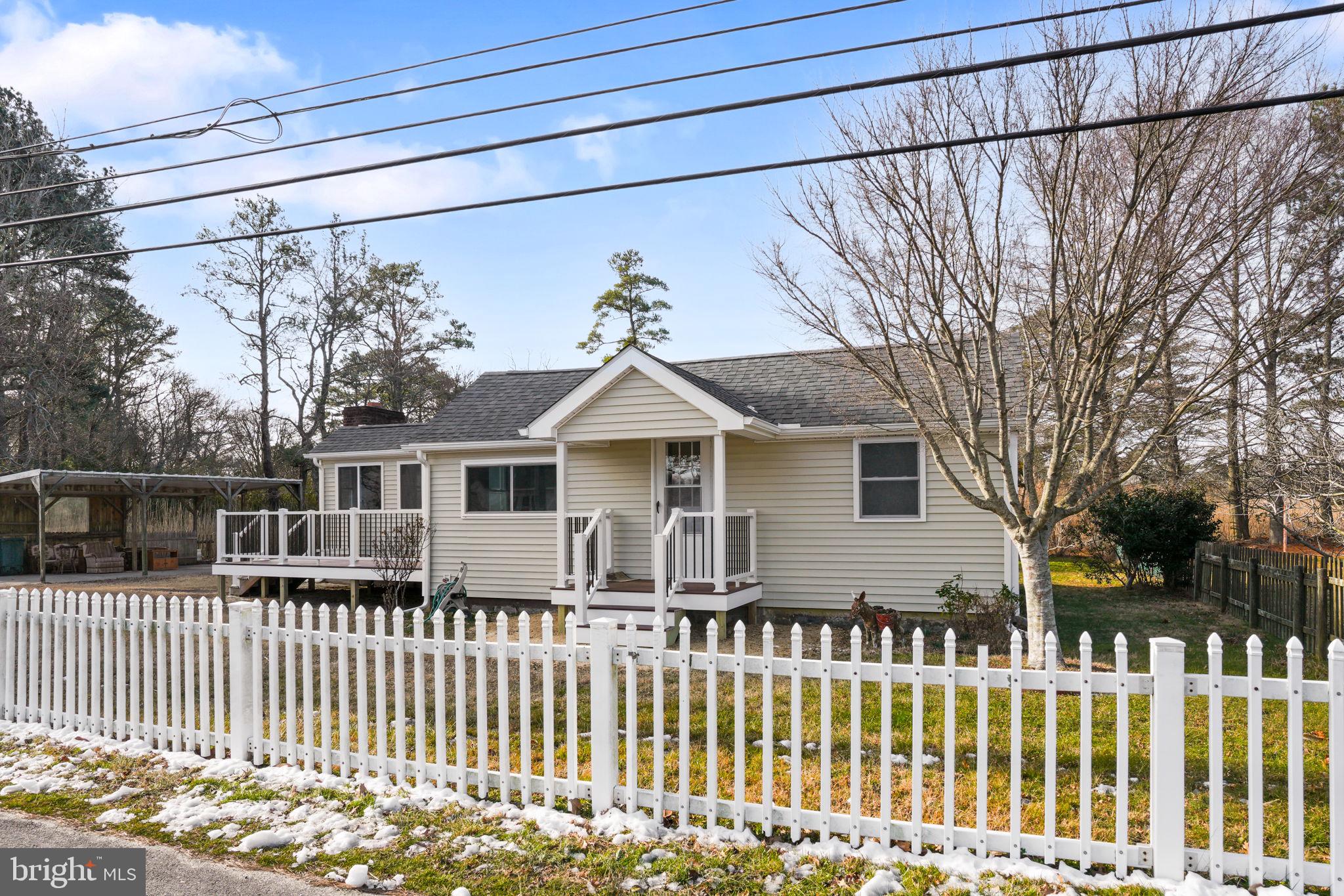 Practically brand new, this beautifully rebuilt rancher on Chincoteague Island offers the perfect blend of modern comfort and coastal charm—just moments from downtown and directly across the street from the beloved Church St Produce, famous for its homemade pies and local favorites.

Rebuilt from the studs, this home features all-new roofing, windows, electrical, plumbing, and more—giving you the peace of mind of new construction with the character of an established setting. Situated on three lots, the property offers generous space, privacy, and plenty of parking with a large driveway and carport.

Inside, enjoy true one-level living with a bright, open layout. The spacious living room welcomes you with a vaulted ceiling, exposed beams, a cozy fireplace (as is), and a beautifully finished wood planked ceiling that adds warmth and character to the space. Luxury vinyl plank flooring flows throughout the main living areas, while fresh carpet adds comfort to both bedrooms. The large eat-in kitchen provides ample space for gatherings and everyday living.

This home features a convenient half bath, a dedicated laundry room for added efficiency, and a spacious full bath designed for comfort. Step outside to enjoy the covered front porch or unwind on the expansive rear deck overlooking the peaceful pond backdrop. A storage shed offers additional room for tools, beach gear, or hobbies.

Located close to Chincoteague’s shops, dining, parks, and waterfront attractions, this home delivers the ideal island lifestyle—whether you're seeking a full-time residence, vacation retreat, or investment opportunity. Move-in ready and thoughtfully upgraded, this is a rare chance to own a like-new home in one of the island’s most convenient and charming locations.