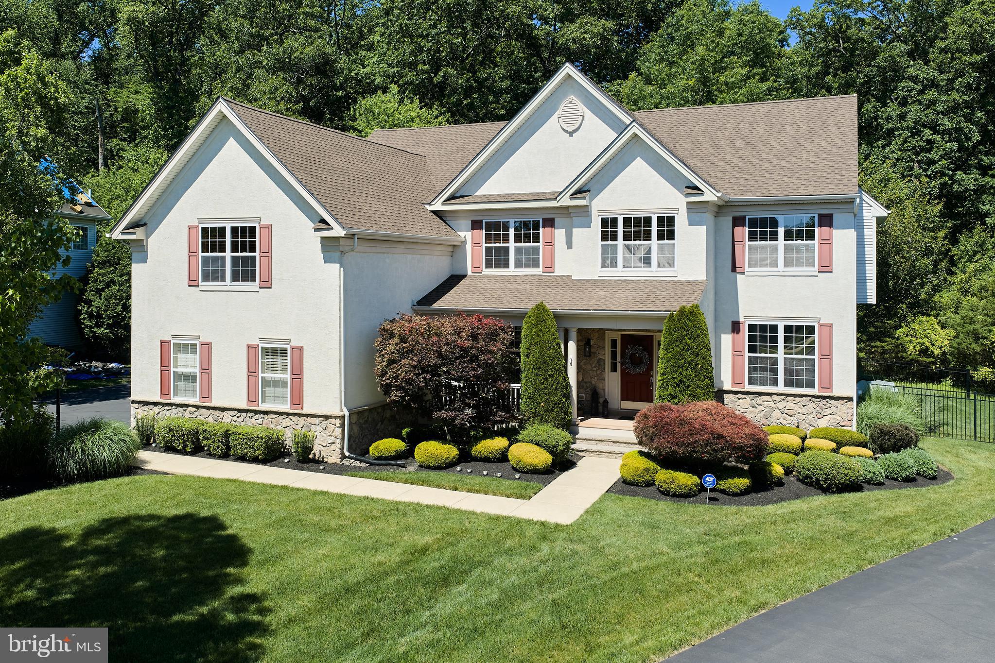 Welcome to 3844 Springtown Road, an exceptional luxury residence nestled on one of the most desirable premium lots in Windsor Square and located within the highly acclaimed Blue Ribbon Central Bucks School District. Perfectly positioned on a beautifully landscaped lot backing to mature woods, this meticulously maintained 5-bedroom, 3.5-bath home offers the ideal blend of elegance, comfort, and privacy. A charming maintenance-free covered front porch with TREX decking welcomes you into a grand foyer featuring hardwood flooring and dual front and rear staircases. French doors open to a versatile private office / fitness room, while the formal living and dining rooms showcase exquisite crown molding, chair rail, and wainscoting, creating elegant spaces for entertaining. The gourmet kitchen is appointed with granite countertops, a center island with seating, stainless steel appliances, and an undermount stainless-steel sink, flowing seamlessly into the spectacular morning room with breakfast bar and abundant natural light. The impressive two-story family room features a cozy gas fireplace with a  wood mantel, creating the perfect gathering space. A well-appointed laundry room with utility sink and cabinetry, along with a powder room, complete the main level. Upstairs, hardwood flooring extends through the hallway, leading to the luxurious owner's suite featuring a spacious sitting room, two walk-in closets with custom organizers,  a frameless glass shower, jacuzzi whirlpool soaking tub, and double vanity. Four additional generously sized bedrooms include a private princess suite with a beautifully renovated en-suite bath and  walk-in shower, while the remodeled hall bath offers a double vanity and tub/shower combination. The finished walk-up lower level is an entertainer's dream, featuring a bar area, game room, theater space, and abundant room for recreation and gatherings. Outdoor living is equally impressive with a large patio overlooking the fully fenced backyard and serene wooded backdrop, creating a private park-like retreat. Additional upgrades include a 3-car side-entry garage with epoxy flooring, a new roof, newly painted first floor, newer dual-zone HVAC systems with two furnaces and two air conditioning units installed in 2020, custom closet organizers, plantation shutters throughout many rooms, radon mitigation system, newer garage doors and a newer aluminum backyard fence. Residents of Windsor Square enjoy a beautifully maintained neighborhood park located at the center of the community, complete with a charming sitting area , playground, and open green space, providing a wonderful gathering place for neighbors and families. Conveniently located just minutes from the charming towns of Doylestown, New Hope, and Newtown, with easy access to Philadelphia, New Jersey, and New York, this extraordinary home offers luxury living, exceptional community amenities, and an unmatched lifestyle.