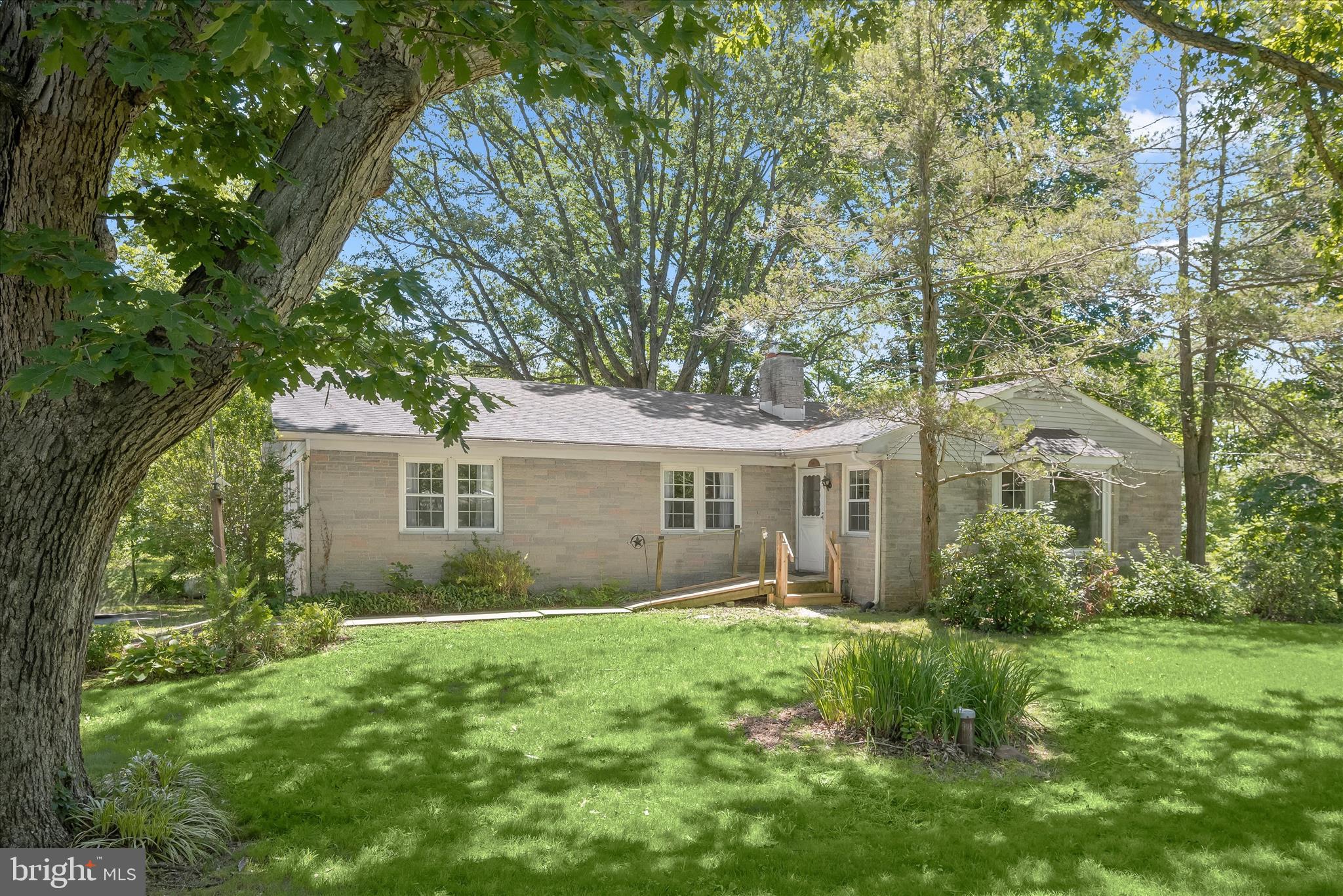 Welcome to 9915 Masser Road, a charming home set on 3.89 peaceful acres in Frederick, offering a serene setting, comfortable living spaces, and endless potential. Ready for its next chapter, this property presents a wonderful opportunity for a new homeowner to add their own style and updates while enjoying the privacy and beauty of the surrounding acreage. The main level features an expansive living room with hardwood floors and a large bow window that fills the space with natural light, while the dining room is anchored by a cozy fireplace and a second bow window with built-in storage, creating a warm and inviting setting for everyday living and entertaining.
The eat-in kitchen offers ample cabinetry, a cooktop, and wall oven, providing a functional layout with room to personalize. Three spacious bedrooms, each with hardwood flooring, and a full bath complete the main level. The lower level adds versatility with a full bath, laundry area, abundant storage space, and direct access to the garage. A roof replacement in 2018 provides added value and peace of mind. With its attractive setting, solid features, and opportunity to make it your own, this property is ready to shine.