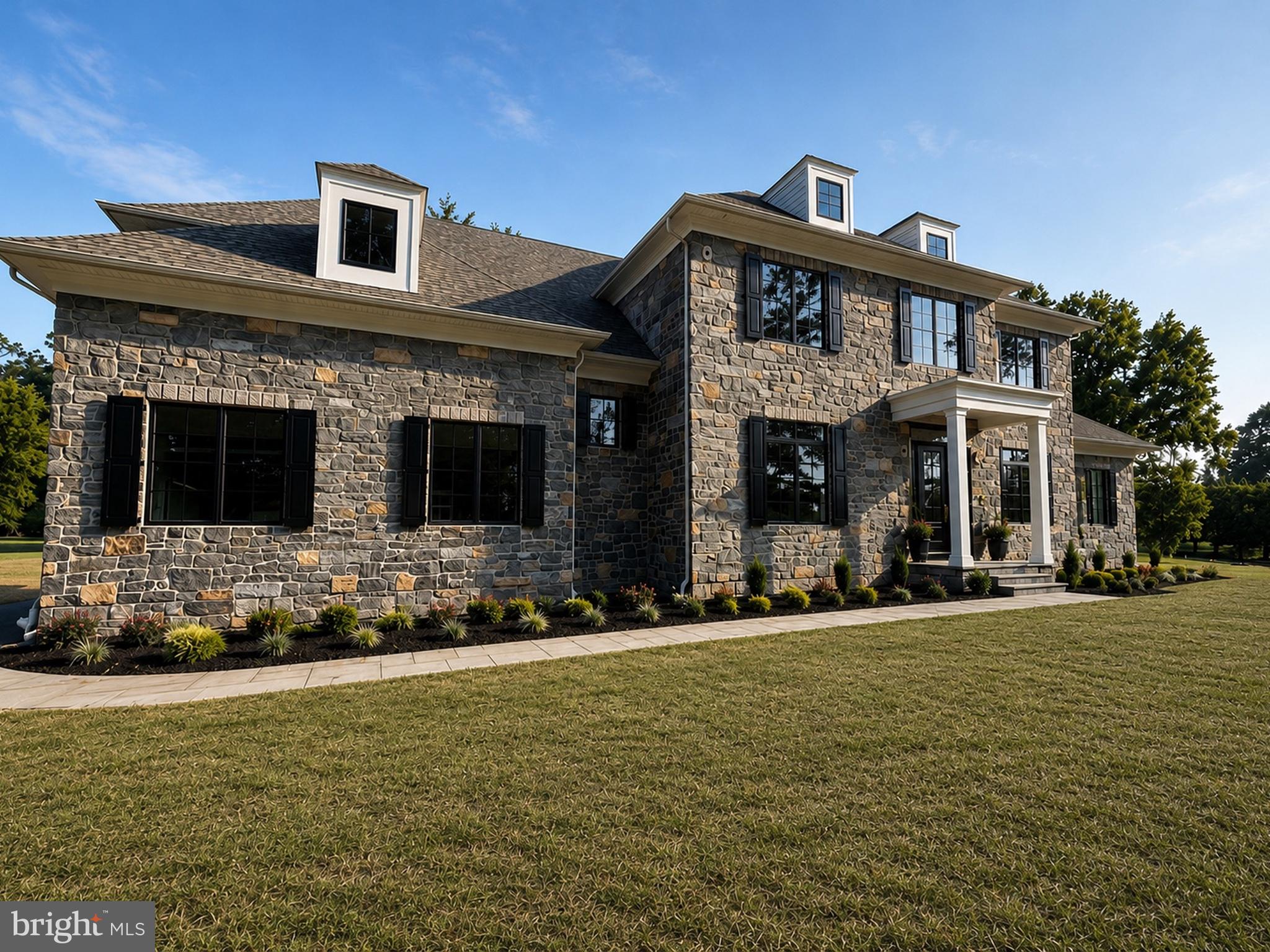 Welcome to 725 W. Curry Drive, Blue Bell, a one-of-a-kind custom-built luxury residence thoughtfully designed with timeless architecture, exceptional craftsmanship, and designer finishes throughout. This stunning new construction offers 5 spacious bedrooms, 6 full bathrooms, 1 powder room, and a beautifully finished basement, creating the perfect balance of elegance, comfort, and functionality.

A grand front elevation featuring a full natural stone façade, Andersen 400 Series black windows, gas lanterns, a bluestone paver walkway, and professionally crafted exterior millwork creates unforgettable curb appeal. Inside, you’ll be welcomed by soaring 10-foot ceilings, rich 5-inch solid white oak flooring, and a striking herringbone foyer that immediately sets the tone for the home’s refined design. Custom molding, extensive millwork, solid-core 8-foot doors, designer lighting, and premium finishes continue throughout every level.

The gourmet kitchen is designed to impress, featuring custom inset cabinetry with brass hardware, honed Carrara marble countertops with an elegant OG edge, a custom range hood, 42-inch ILVE range, 42-inch paneled Monogram refrigerator and an oversized butler’s pantry, creating an ideal space for both everyday living and entertaining.

The adjoining family room showcases exposed oak ceiling beams, custom built-in bookcases, and a stunning marble-surround gas fireplace. Additional gathering spaces include a sophisticated sitting room with a coffered ceiling, while the luxurious primary suite offers a beautifully detailed tray ceiling and a spa-inspired bath designed for everyday relaxation.

Every bedroom enjoys the privacy of an en-suite bathroom finished with designer tile and premium Kingston Brass plumbing fixtures, while Kohler fixtures and thoughtfully selected finishes reinforce the home’s exceptional quality throughout.

Designed for today’s lifestyle, the home also features a custom laundry room with inset white oak cabinetry, a functional mudroom with built-in bench seating and storage, a fully finished basement offering additional living and entertaining space, and a spacious three-car garage.
Outside, enjoy seamless indoor-outdoor living with a rear brick patio complete with a custom exterior fireplace—perfect for relaxing evenings or entertaining guests year-round.

Constructed with quality in mind, this exceptional home also includes a dual-zone Carrier HVAC system, 400-amp electrical service, CertainTeed architectural roofing, Hardie siding on the rear elevation, and numerous additional luxury upgrades throughout.

Perfectly situated in the heart of Blue Bell, 725 W. Curry Drive offers the rare opportunity to own a truly custom-built home where every detail has been carefully considered. This is luxury living at its finest.