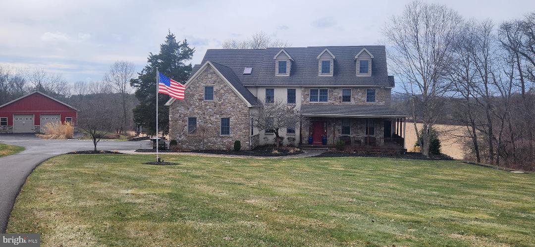 Bucks County estate on over 18 scenic acres, this custom-built Colonial farmhouse–style home offers a thoughtfully designed floor plan, expansive views , and a peaceful setting surrounded by 13 acres of open pastures and 5 wooded acres. The stone and stucco exterior is complemented by newer custom decks on both the first and second levels, providing wonderful spaces to enjoy the panoramic landscape.
The main level welcomes guests with a dramatic two-story foyer that opens to the living room and formal dining room. A two-story family room with a stone fireplace and a wall of windows brings in abundant natural light and overlooks the backyard. A spacious office offers a bright and comfortable work-from-home environment.
The kitchen features stainless steel appliances, granite countertops, gas cooking, and generous workspace. A powder room and an expansive laundry room complete the main level.
Upstairs, the main bedroom suite includes two walk-in closets, a sitting room with fireplace, a large primary bath, a bonus room, and a staircase leading to an additional unfinished attic area offering potential for future use. Additional bedrooms and full baths provide comfortable accommodations for family and guests.  Additionally features a back staircase with access to kitchen. 
The fully finished walk-out basement features durable luxury vinyl plank flooring and includes a full bathroom, creating flexible space for recreation, hobbies, or extended living.
Additional features include an attached three-car heated garage, whole-house generator, and a custom in-ground heated salt water pool with spa. 
A standout feature is the impressive approximately 2,400 square foot barn with an additional 720 square foot overhang, offering radiant propane-heated floors, insulated walls, 12-foot ceilings, three 10x10 insulated garage doors, steel siding and roofing, stone front exterior, full electric service, and an unfinished second floor with electric—ideal for storage, workshop space, or a variety of permitted uses.
Conveniently located near the shops, dining, and cultural attractions of both Doylestown and New Hope, with access to major commuter routes.