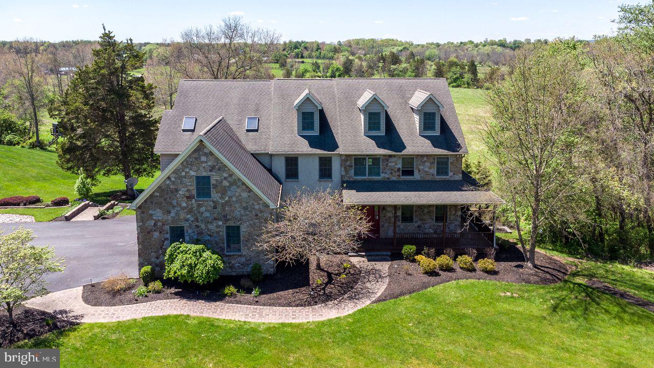 Bucks County estate on over 18 scenic acres, this custom-built Colonial farmhouse–style home offers a thoughtfully designed floor plan, expansive views , and a peaceful setting surrounded by 13 acres of open pastures and 5 wooded acres. The stone and stucco exterior is complemented by newer custom decks on both the first and second levels, providing wonderful spaces to enjoy the panoramic landscape.
The main level welcomes guests with a dramatic two-story foyer that opens to the living room and formal dining room. A two-story family room with a stone fireplace and a wall of windows brings in abundant natural light and overlooks the backyard. A spacious office offers a bright and comfortable work-from-home environment.
The kitchen features stainless steel appliances, granite countertops, gas cooking, and generous workspace. A powder room and an expansive laundry room complete the main level.
Upstairs, the main bedroom suite includes two walk-in closets, a sitting room with fireplace, a large primary bath, a bonus room, and a staircase leading to an additional unfinished attic area offering potential for future use. Additional bedrooms and full baths provide comfortable accommodations for family and guests.  Additionally features a back staircase with access to kitchen. 
The fully finished walk-out basement features durable luxury vinyl plank flooring and includes a full bathroom, creating flexible space for recreation, hobbies, or extended living.
Additional features include an attached three-car heated garage, whole-house generator, and a custom in-ground heated salt water pool with spa. 
A standout feature is the impressive approximately 2,400 square foot barn with an additional 720 square foot overhang, offering radiant propane-heated floors, insulated walls, 12-foot ceilings, three 10x10 insulated garage doors, steel siding and roofing, stone front exterior, full electric service, and an unfinished second floor with electric—ideal for storage, workshop space, or a variety of permitted uses.
Conveniently located near the shops, dining, and cultural attractions of both Doylestown and New Hope, with access to major commuter routes.