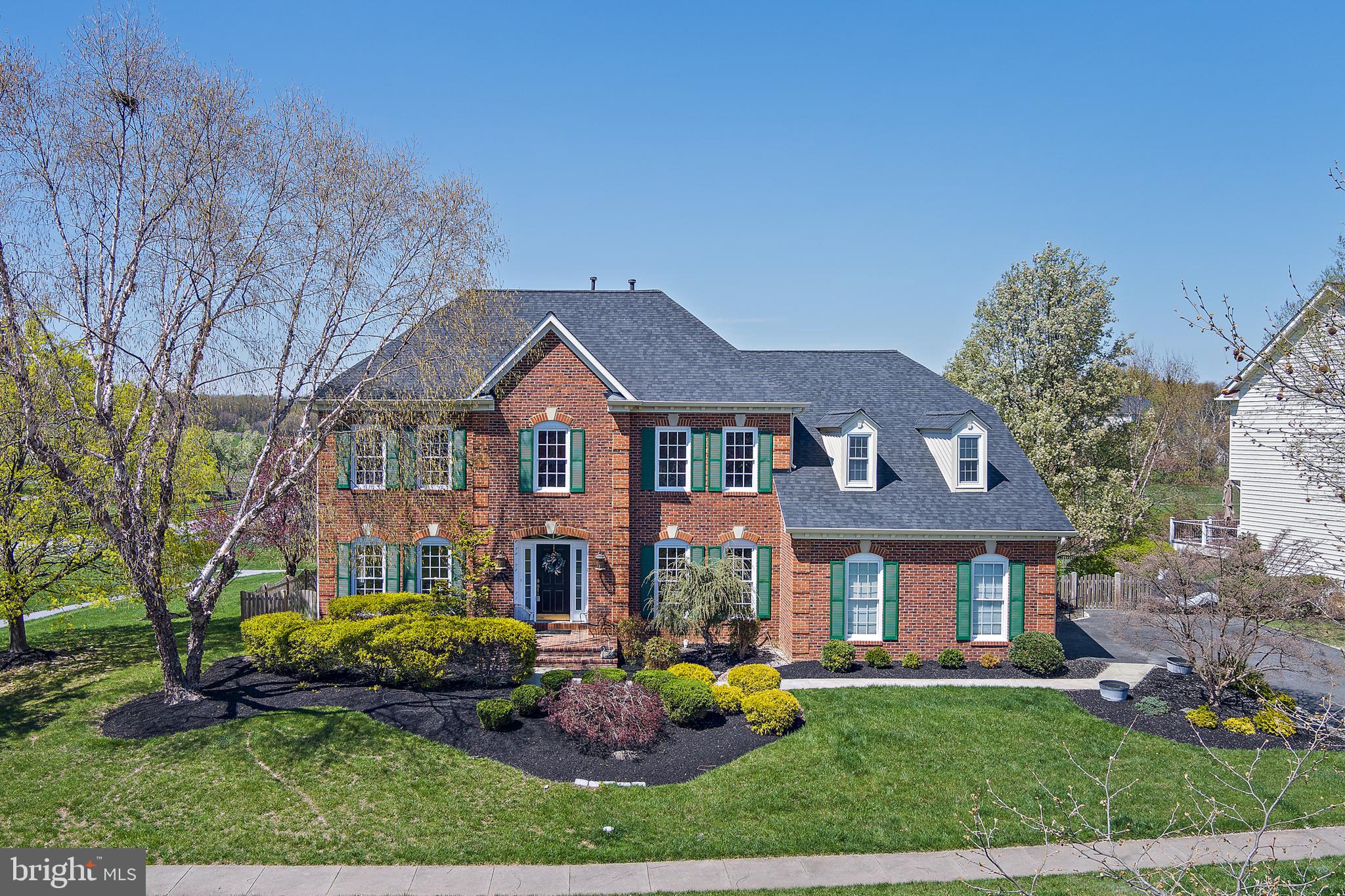 OFER DEADLINE SET FOR MONDAY, APRIL 14th AT NOON.  Welcome to 9826 Mahogany Run – A Stately Colonial in Coveted Holly Hills.  Nestled in the highly sought-after Holly Hills golf course community, this elegant brick-front colonial offers timeless style, abundant space, and modern comfort in one of the area’s most desirable neighborhoods.  Step inside to a grand two-story foyer that flows into spacious living and dining areas—perfect for entertaining. The heart of the home is the stunning two-story family room, featuring a gas fireplace with a striking stone surround and hardwood floors that extend throughout the entire main level.  The spacious kitchen is a chef’s dream with stainless steel appliances, a large island, abundant cabinetry and counter space, including a convenient serving area seamlessly connecting the kitchen and dining area, perfect for entertaining.  A bright breakfast area opens directly onto a beautiful composite deck with stairs leading down to a charming patio—ideal for outdoor dining and relaxing in the beautifully landscaped, fenced-in backyard.  Enjoy tranquil views of a distant pond as you unwind in this peaceful setting.  A custom-built shed, perfectly matching the home’s design, sits in the backyard—ideal for neatly storing lawn and garden tools while complementing the home’s classic charm. Also on the main level is a private home office with custom built-in bookshelves, a laundry room just off the kitchen, and a half bath for guests. Entry from the two-car side-entry garage offers added convenience. Upstairs, brand-new carpet enhances the luxurious comfort of the upper level. The expansive primary suite features a walk-in closet and an ensuite bath with double vanities, a soaking tub, a large shower, and a private water closet. Bedroom 2 includes its own ensuite bath—perfect for guests—while Bedrooms 3 and 4 share an adjoining ensuite, with dual vanities and a private water closet and shower area.  The fully finished lower level also boasts brand-new carpet and offers incredible versatility: enjoy movie nights, host game-day gatherings, or set up a home gym. A wet bar with sink and fridge makes entertaining a breeze. This level also includes a fourth full bathroom, a private bonus room ideal for a second home office or guest suite, and a large storage area.  Homes in Holly Hills are rarely available—don’t miss this incredible opportunity to own a meticulously maintained home in a premier location!  Schedule your private tour today and fall in love with 9826 Mahogany Run!