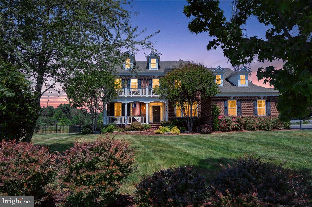 Welcome to 42458 Reservoir Ridge Place, nestled in one of Ashburn's most exclusive and rarely available communities. Homes in Reservoir Ridge seldom come to market, making this an extraordinary opportunity for the discerning buyer seeking something truly special. Built in 2014, this stunning 5 bedroom, 4.5 bath colonial delivers the space, finishes, and resort-style amenities that today's discerning families have been waiting for. From the moment you arrive, the classic brick façade, charming covered front porch, and professionally landscaped grounds bursting with color and manicured to perfection set the tone for the exceptional living experience that awaits inside.

Step through the elegant foyer and be greeted by rich hand-scraped engineered hardwood floors that flow throughout the main level, complemented by crown molding and an open, light-filled layout designed for both everyday living and effortless entertaining. The formal living and dining rooms provide sophisticated spaces for gathering, while the expansive family room anchored by a striking stone fireplace opens seamlessly to the gourmet kitchen, the true heart of this home.

The chef's kitchen is a masterpiece of form and function, boasting white shaker cabinetry, gleaming dark granite countertops, a large center island with seating for four, stainless steel appliances including a double wall oven and French door refrigerator, a gas cooktop with pot filler, tile backsplash, and a generous breakfast nook. A main level office and convenient half bath complete the first floor.

Upstairs, the primary suite is nothing short of spectacular. A generous 29.5 by 16.5 foot retreat featuring a dedicated sitting area, a massive walk-in closet, private balcony access, and a spa-inspired en suite bath that is sure to impress. Three additional bedrooms offer exceptional space and flexibility. Two share a well-appointed Jack and Jill bath and a third is served by its own full bath, ideal for guests or extended family.

The expansive lower level is mostly finished and offers incredible versatility with a massive recreation room, a full bath, a bonus room, and a partially finished workshop and office space with endless potential. Whether you envision a home gym, media room, or play space, the possibilities are truly endless. Please note the lower level bed room is non-conforming as it does not contain a closet. Square footage based on floor plan measurements.

The true crown jewel of this property is the resort-caliber backyard. Step onto the covered main level deck complete with three ceiling fans, a natural gas grill, and sweeping views of the lush private yard and you will never want to leave. Below, a stunning flagstone patio surrounds the heated saltwater pool, spa hot tub, and beautiful stone fire pit creating an outdoor entertaining experience that rivals any luxury resort. 

Professionally designed and meticulously maintained landscaping frames every inch of the property with lush garden beds, ornamental grasses, mature trees, and elegant hardscaping that deliver stunning curb appeal and privacy in every season. The oversized 3 car garage completes this extraordinary offering.
This is not just a home. It is a lifestyle. Welcome to 42458 Reservoir Ridge Place.