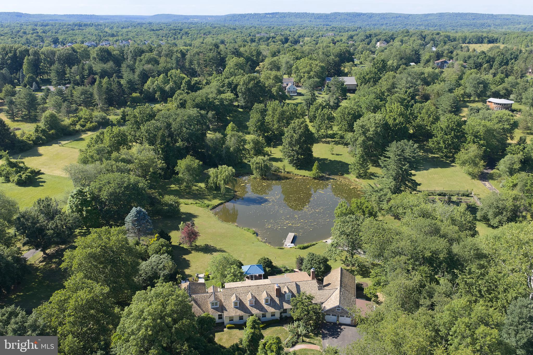 Welcome to 941 Mt Eyre Rd, an enchanting haven offering serenity, privacy, and water views!  Situated on a private six-acre Upper Makefield parcel overlooking the spring-fed one-acre pond, this grand Cape Cod home offers space, functionality, and comfort for family and guests alike.  Enter the front door and the charming straight-through Foyer draws your eye out to the lushly landscaped rear patio, with covered dining area, and pond beyond.  A gracious Living Room with artisan crafted wood-burning fireplace opens to a spacious Dining Room with beautiful sight lines out to the lushly landscaped patio.   A generously proportioned Kitchen can accommodate multiple chefs, and features counter seating and large Breakfast Room with beautiful outdoor views.  The Kitchen opens to the expansive Family Room featuring grand wood burning fireplace and hand crafted built-ins.  Crossing the elegant Family Room Foyer, an expansive Bonus Suite with direct outdoor access can fulfill your particular need, be it for recreation, lounging, or guests.  Below, another Bonus Room features a full ensuite bath and private access to serene outdoor seating space overlooking the pond.  From the main Foyer, you'll find a convenient Powder Room, Office, and hallway to an expansive  Primary Suite.  The grand Primary Bedroom features beautiful views to the lush landscaping, and French Door access to a private patio area.  A luxurious Primary Bath features handcrafted tile work, spacious  shower, jetted tub, and plentiful storage (designed to accommodate a sauna).  A kitchenette perfect for morning coffee, two walk-in closets, and a cozy Sitting Room with patio access complete the Primary Suite.  Upstairs, you'll find another primary suite-sized Bedroom with ensuite bath, two additional Bedrooms, and a Hall Bath, all with beautiful pond views.  An open Bonus Space adjoining these bedrooms is great for lounging, TV watching, video games, or homework.  Outside an attached two-car garage, potting shed,  and storage shed add to your convenience.  Blue Ribbon Council Rock North schools.  Commuter's dream location.... 1 minute to I-295.... 35 minutes to Center City Philadelphia, 20 minutes to Princeton, 15 minutes to Amtrak station to NYC.   A completely tranquil setting yet convenient to everything, this home will recharge your soul.... make it yours today!